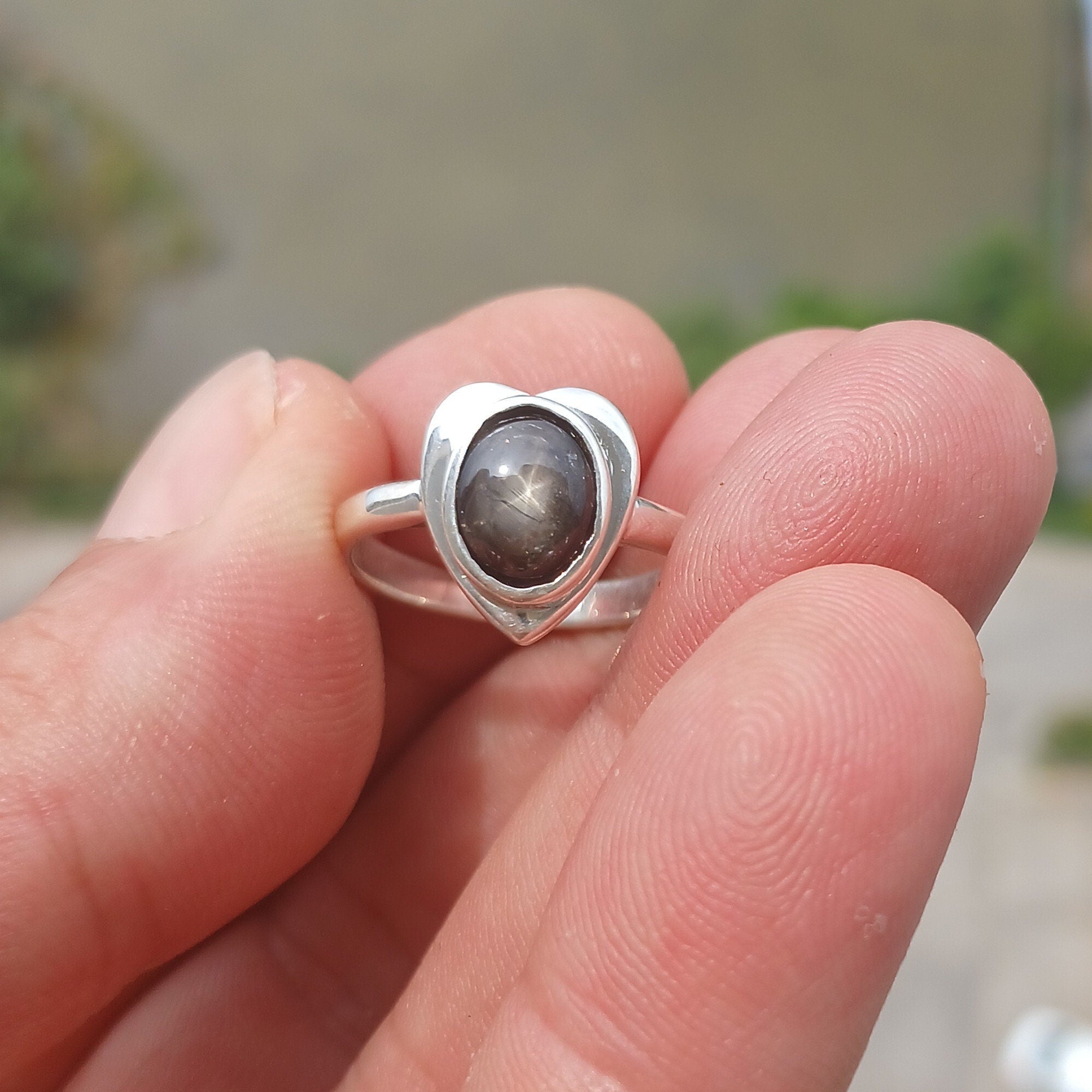 Elegant Black Star Sapphire Ring in sterling silver with an oval-shaped black stone and polished finish.