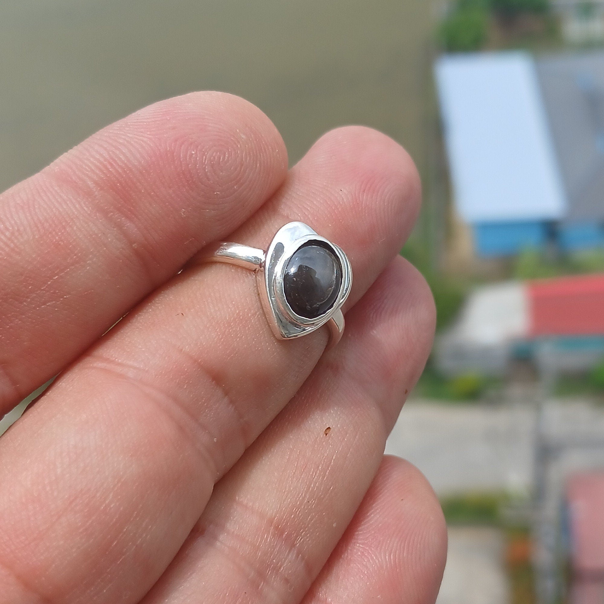 Elegant Black Star Sapphire Ring in sterling silver with an oval-shaped black stone and polished finish.