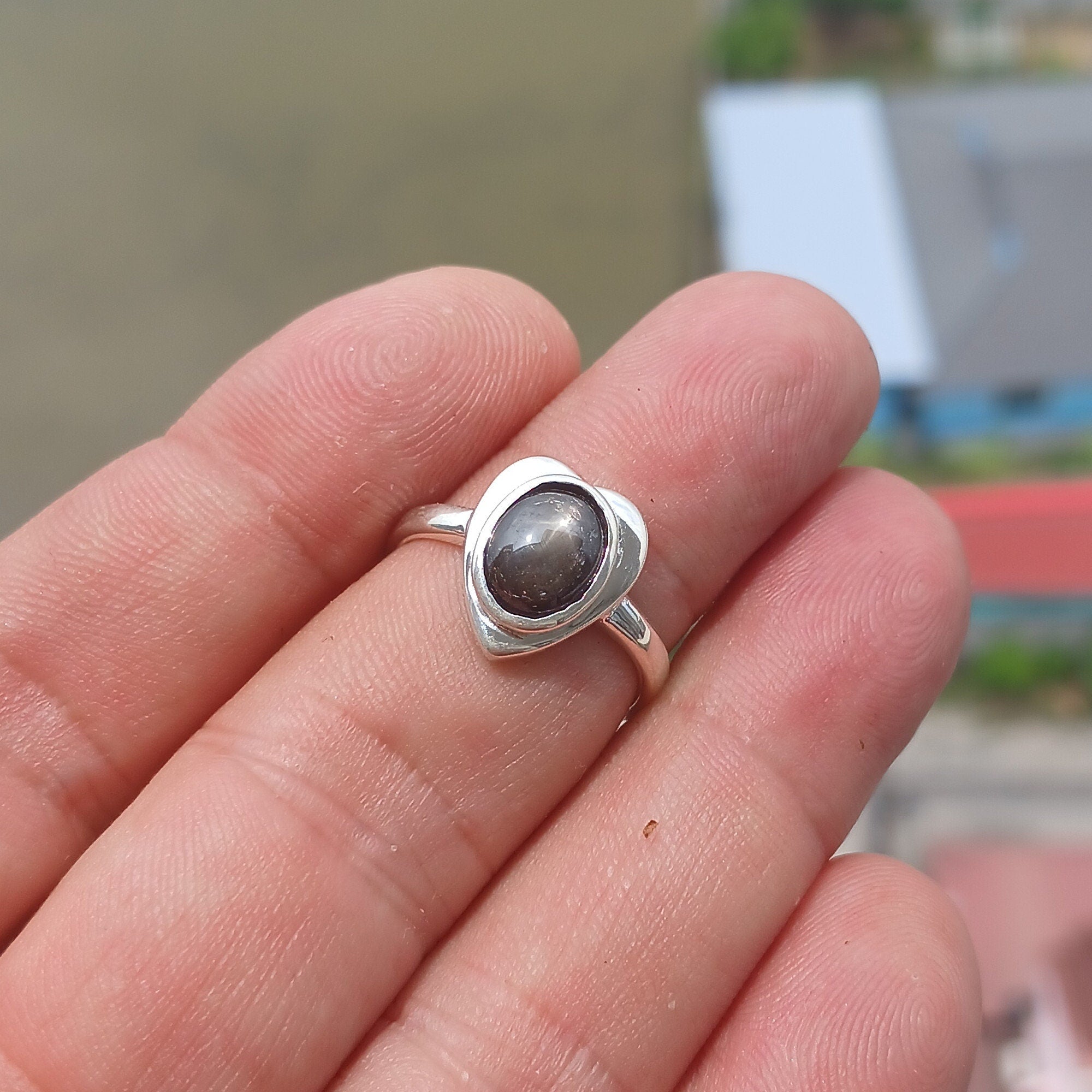 Elegant Black Star Sapphire Ring in sterling silver with an oval-shaped black stone and polished finish.