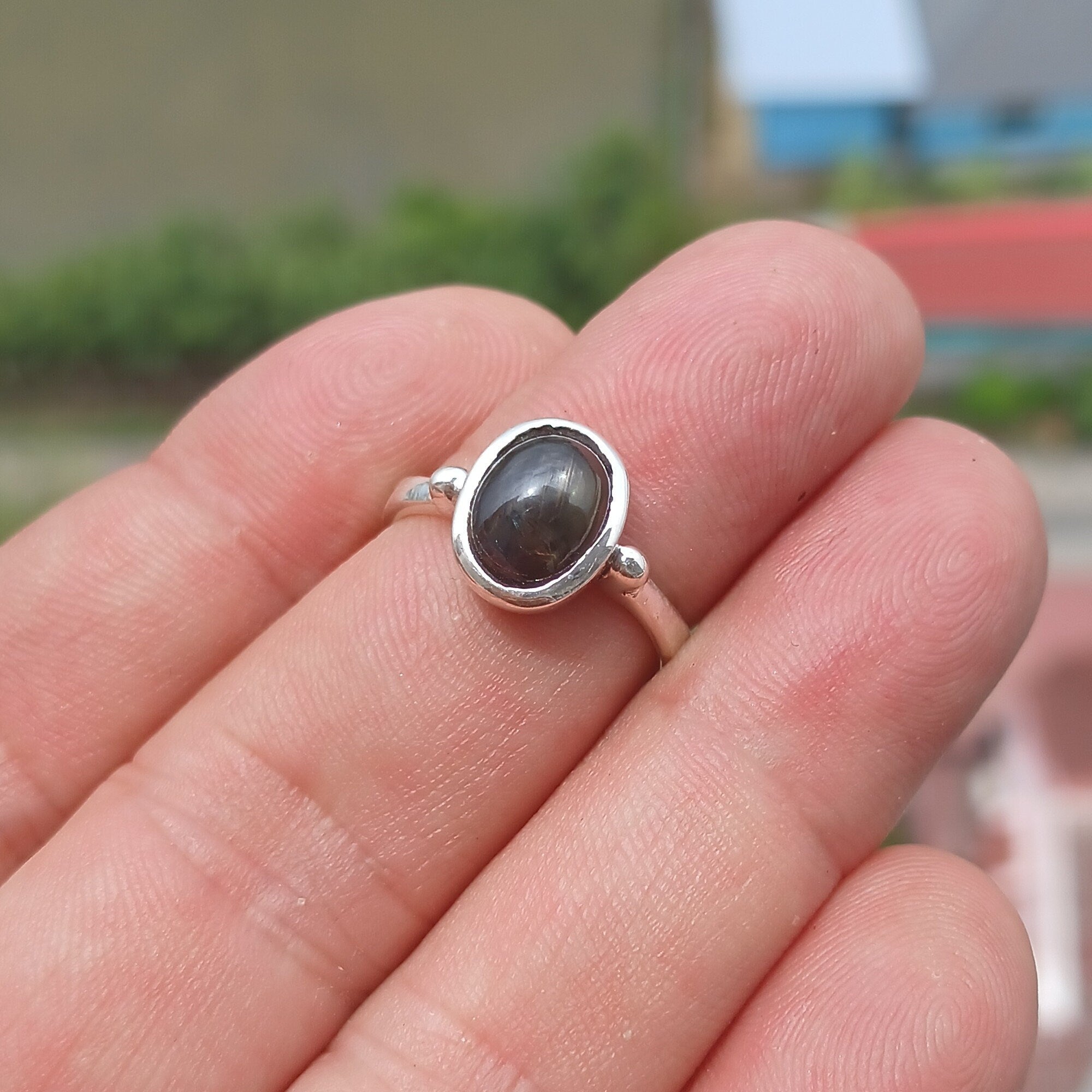 Elegant Black Star Sapphire Ring in sterling silver with a polished finish, featuring an oval-shaped black sapphire stone.