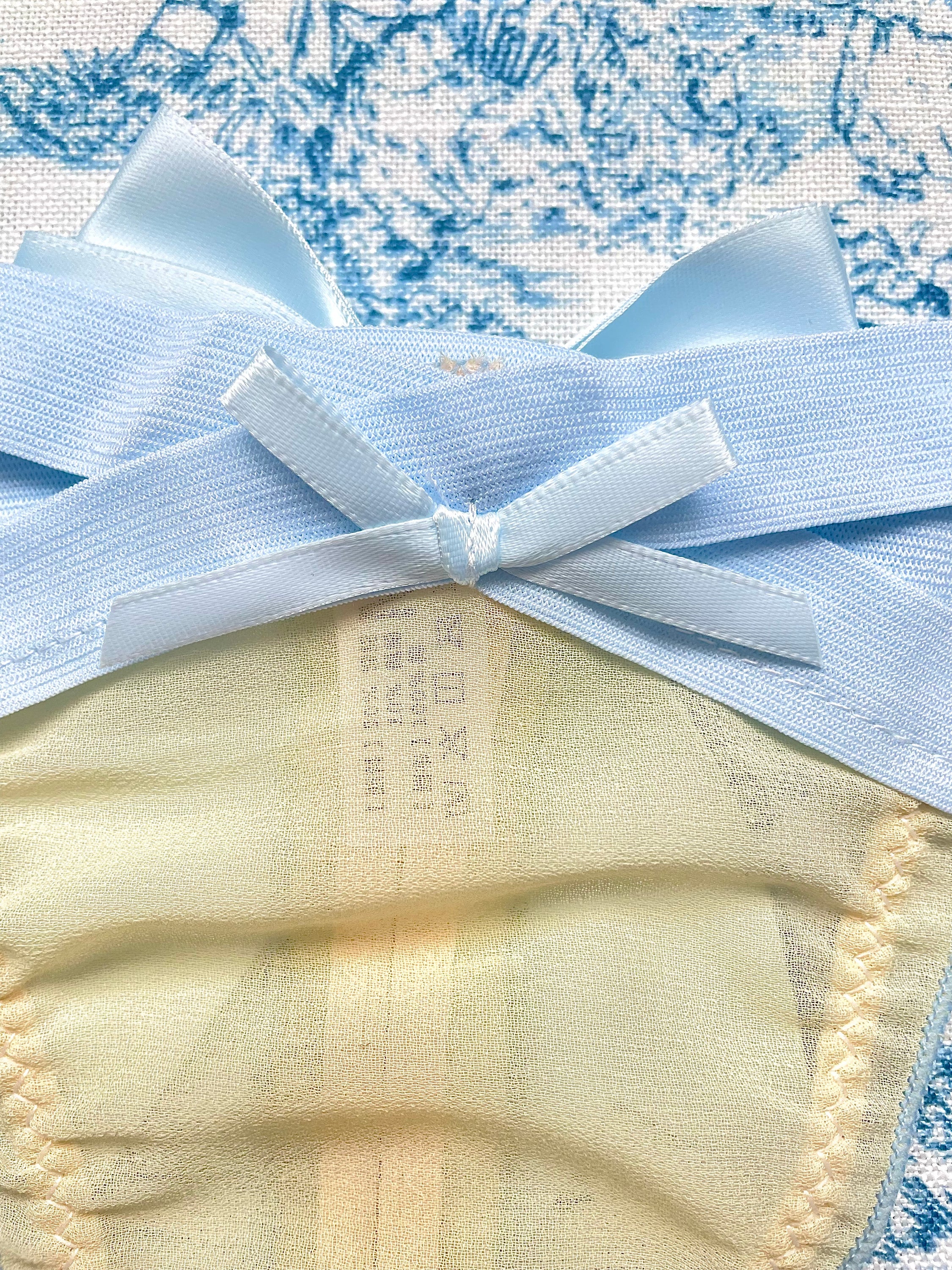 Blue Strap Bow Panty featuring tan mesh and blue satin bow, showcasing elegant design and comfort.