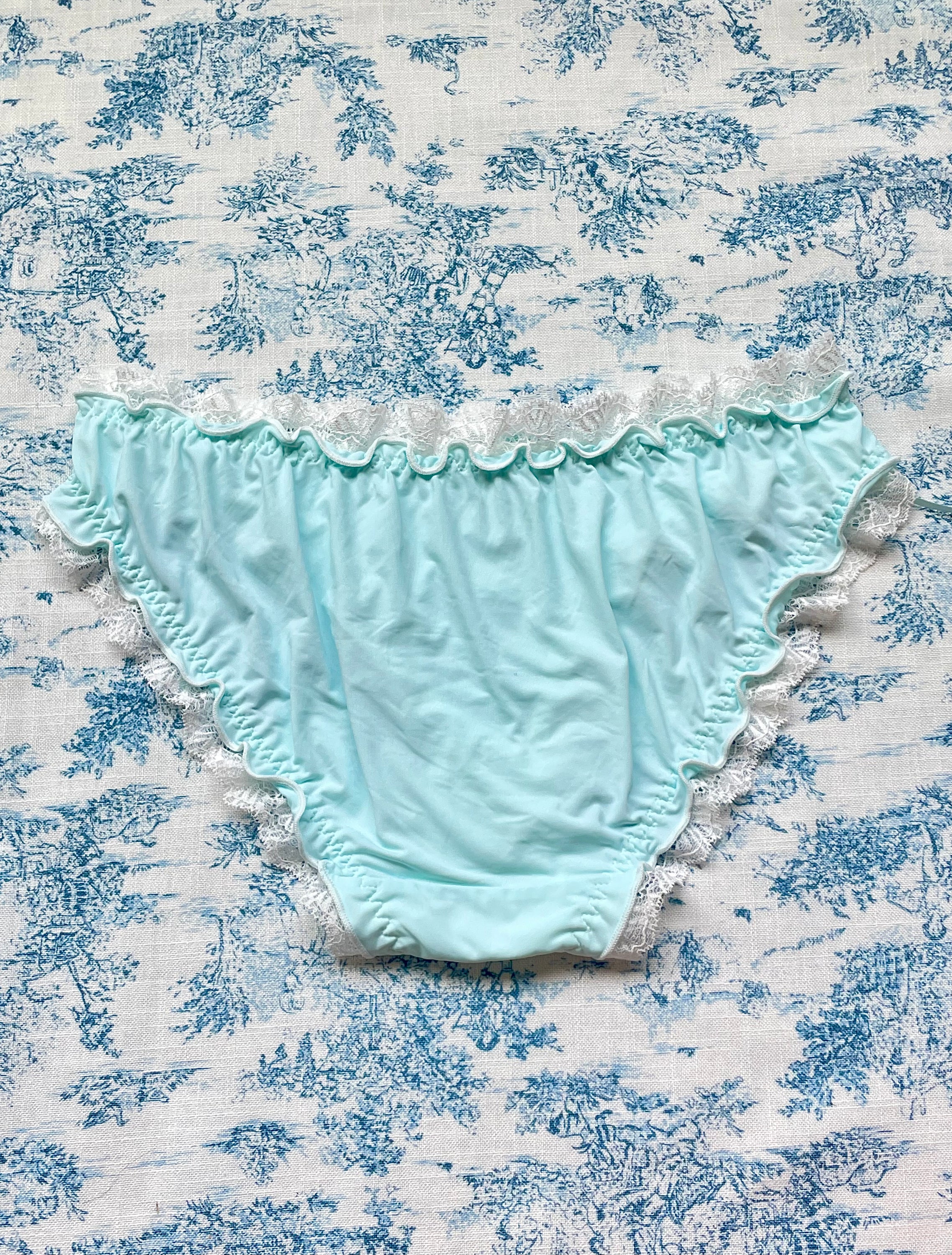 Blue and white lace trim panty featuring a heart design and bow details, crafted from 100% cotton lining.