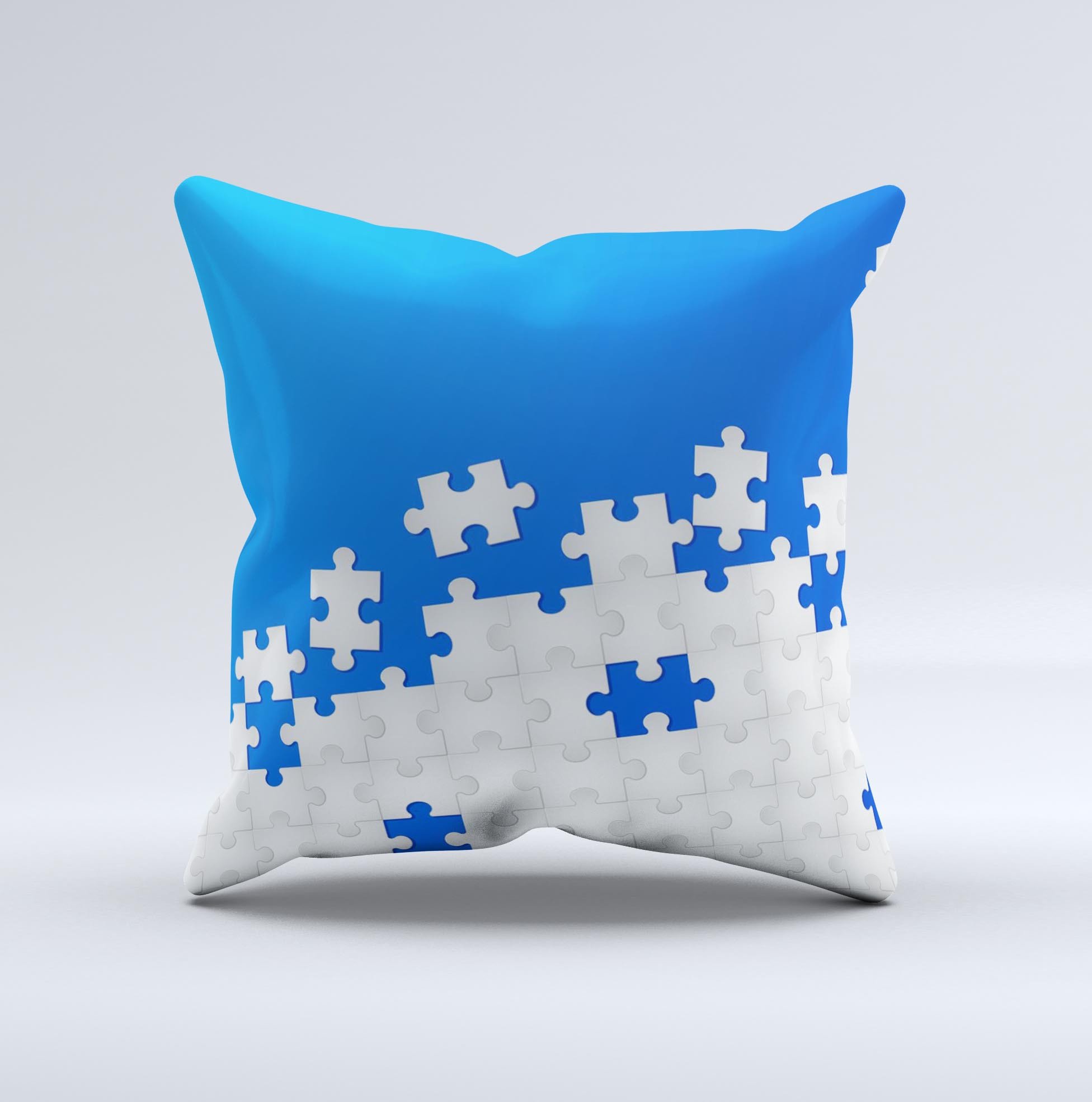 Blue and white decorative throw pillow with scattered puzzle design, handcrafted in Virginia, showcasing unique ink-fuzed graphics.