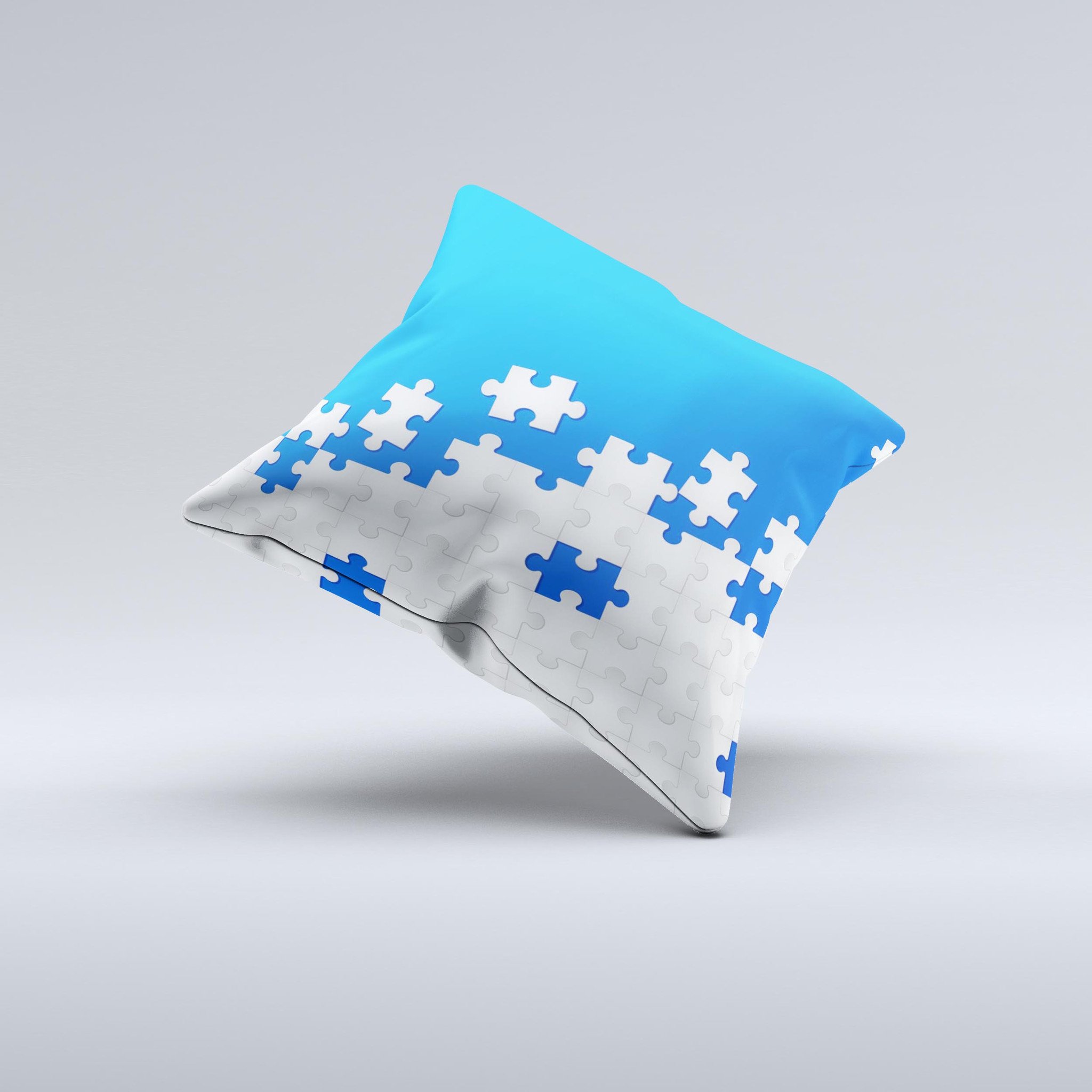 Blue and white decorative throw pillow with scattered puzzle design, handcrafted in Virginia, showcasing unique ink-fuzed graphics.