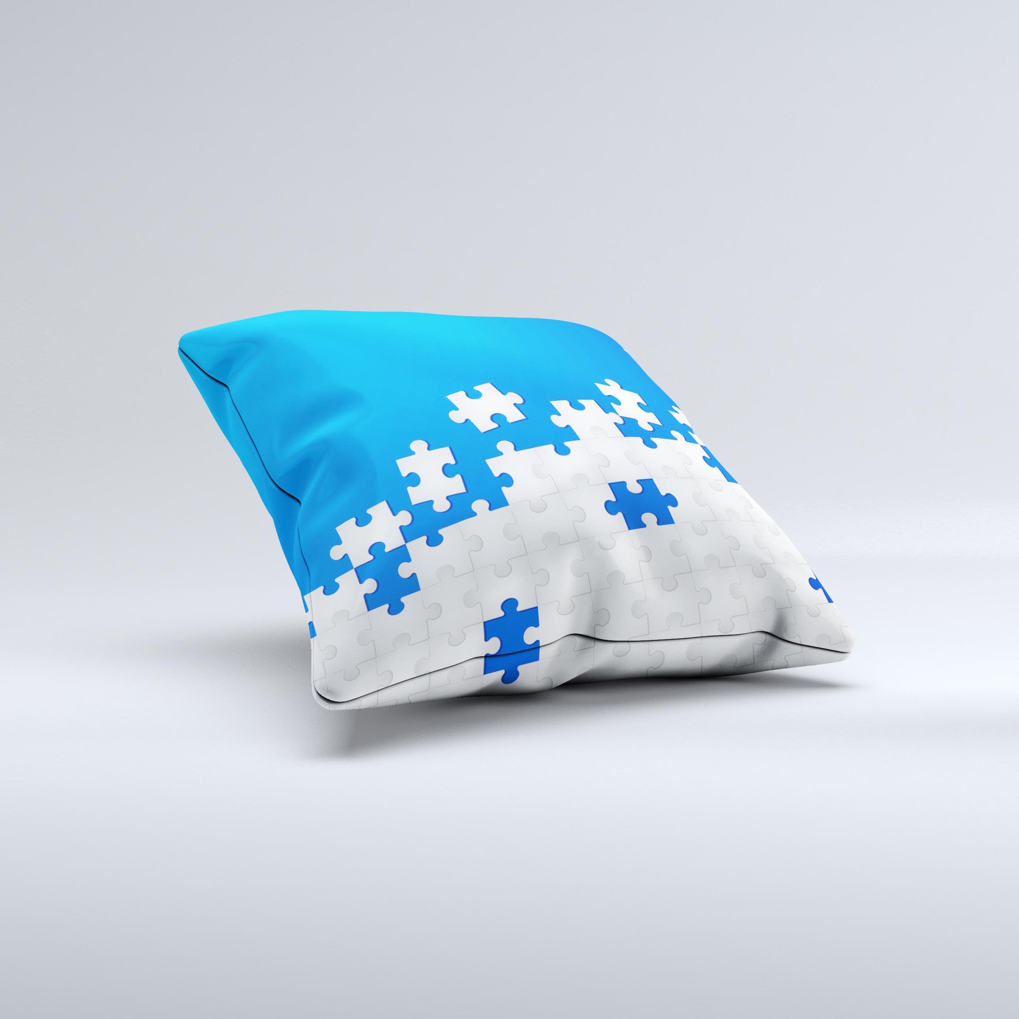 Blue and white decorative throw pillow with scattered puzzle design, handcrafted in Virginia, showcasing unique ink-fuzed graphics.