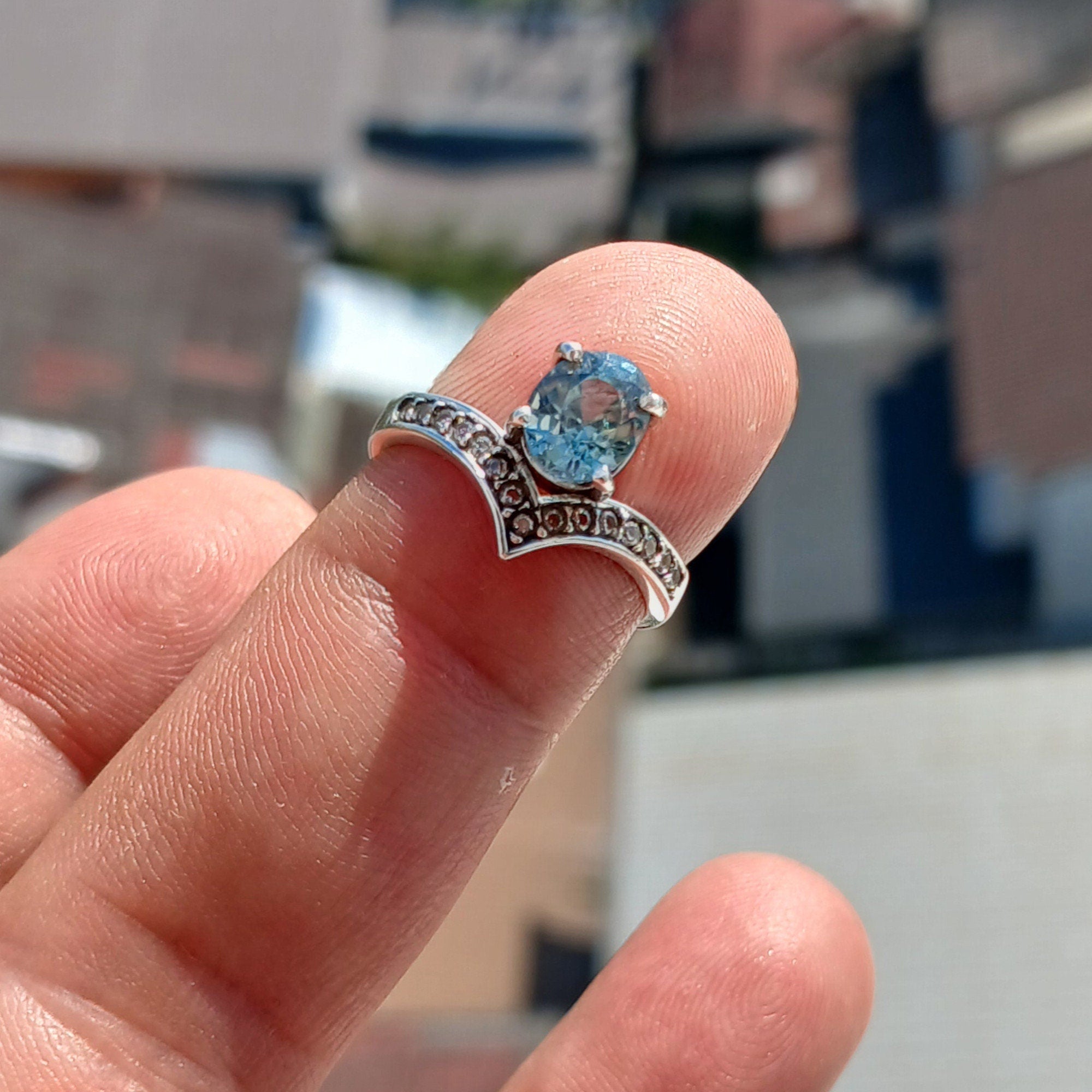 Handmade Blue Zircon Ring in sterling silver featuring an oval cut zircon and 15 white CZ stones, showcasing a polished finish.