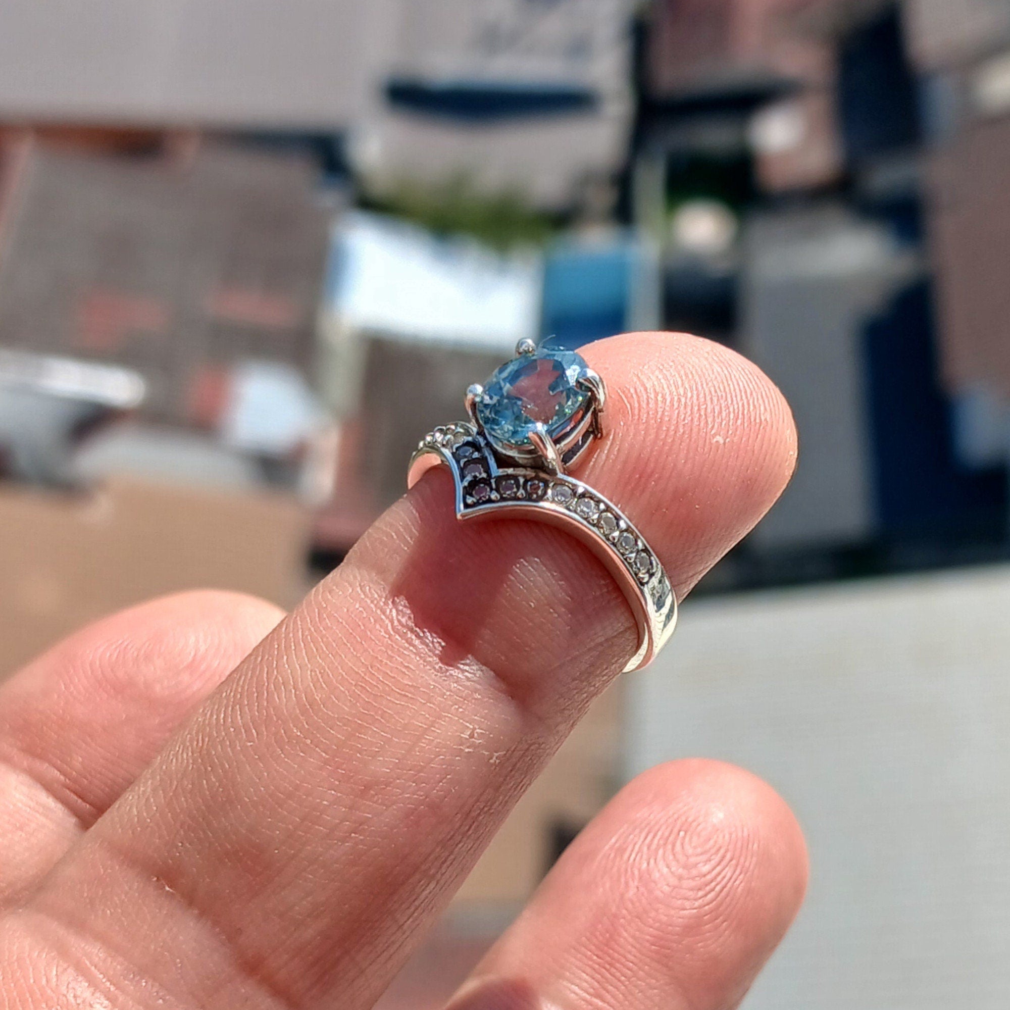 Handmade Blue Zircon Ring in sterling silver featuring an oval cut zircon and 15 white CZ stones, showcasing a polished finish.