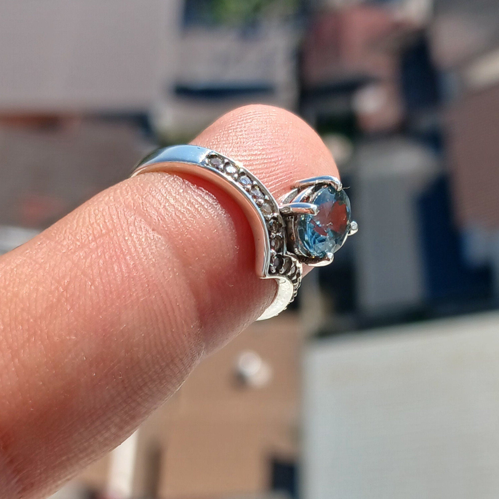 Handmade Blue Zircon Ring in sterling silver featuring an oval cut zircon and 15 white CZ stones, showcasing a polished finish.