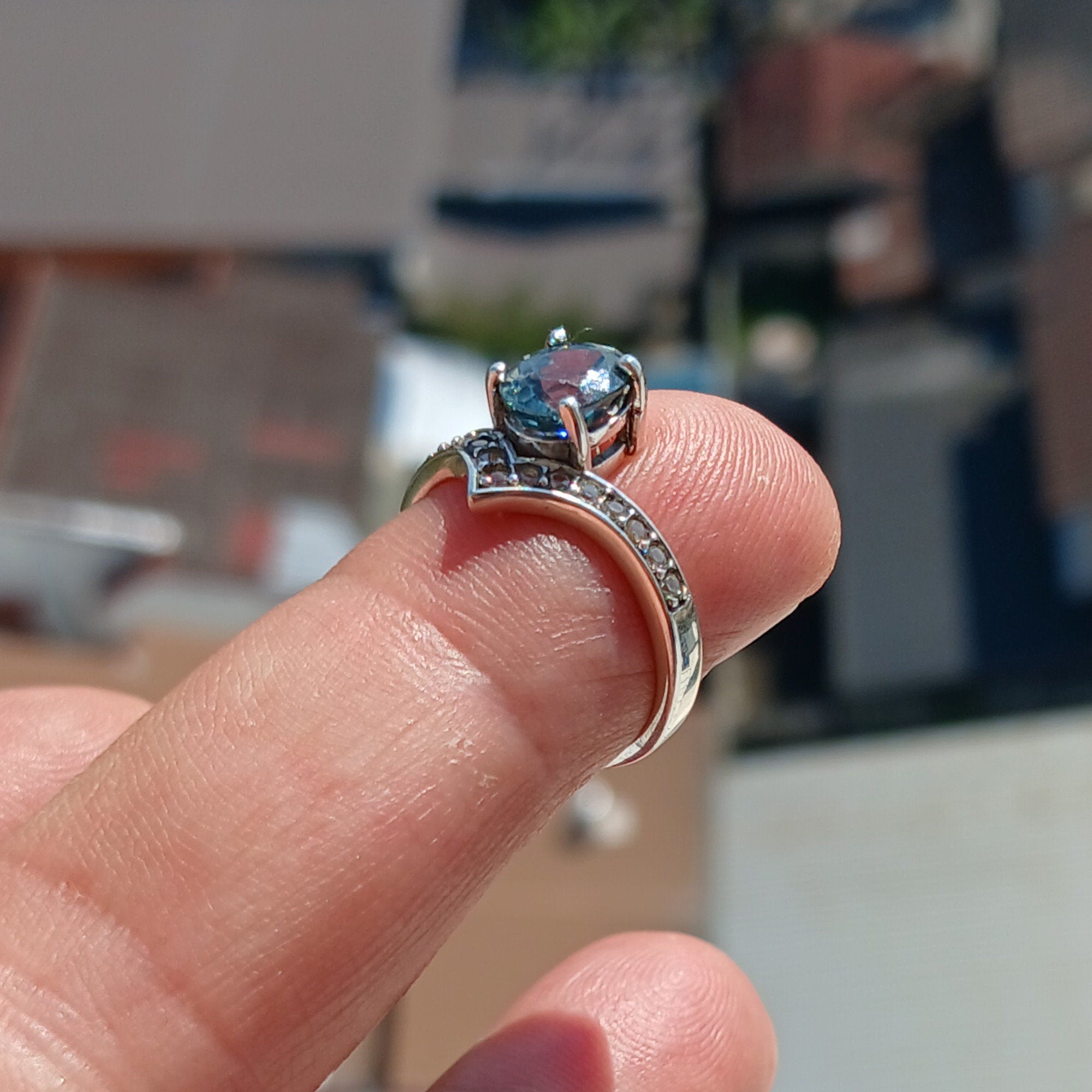 Handmade Blue Zircon Ring in sterling silver featuring an oval cut zircon and 15 white CZ stones, showcasing a polished finish.