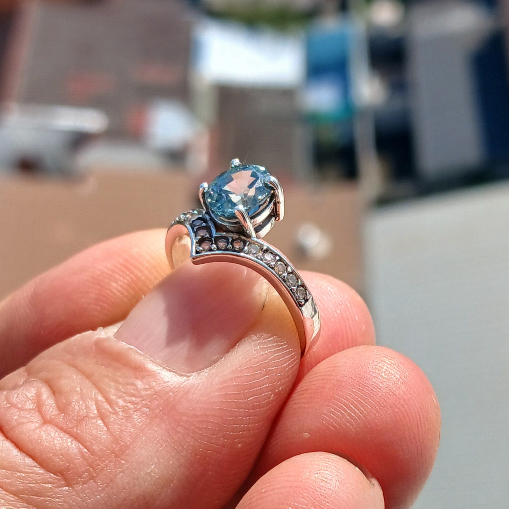 Handmade Blue Zircon Ring in sterling silver featuring an oval cut zircon and 15 white CZ stones, showcasing a polished finish.