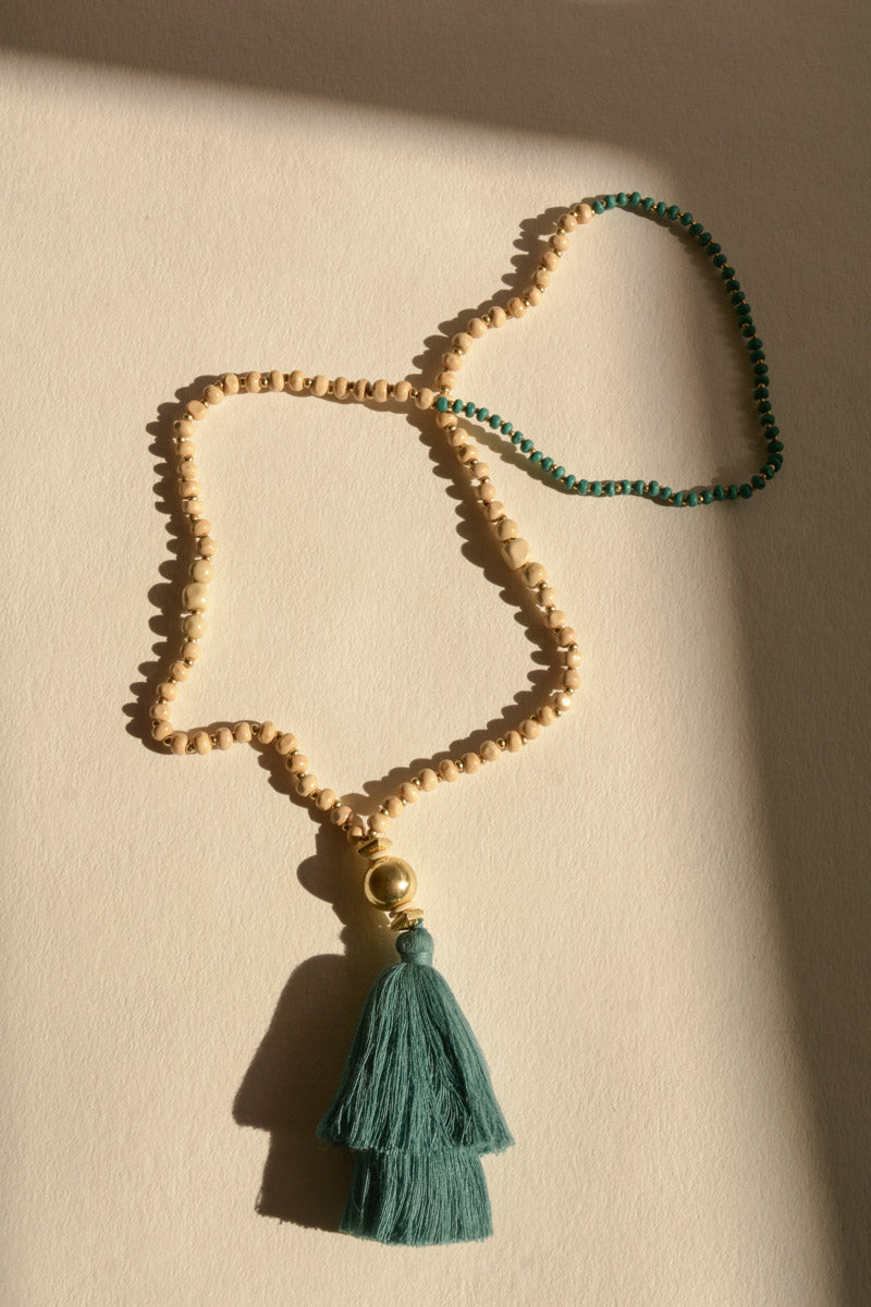 A long bohemian beaded necklace featuring colorful beads and stylish tassels, perfect for a chic look.