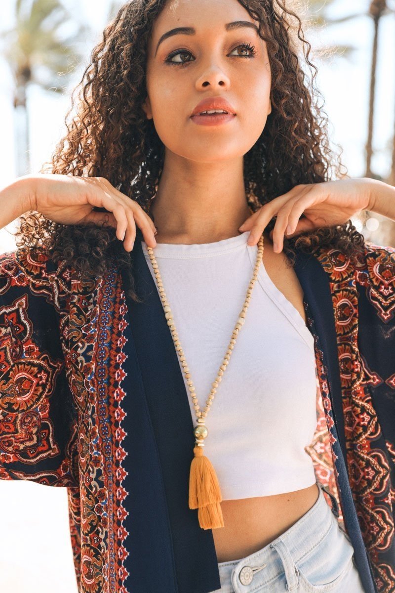 A long bohemian beaded necklace featuring colorful beads and stylish tassels, perfect for a chic look.