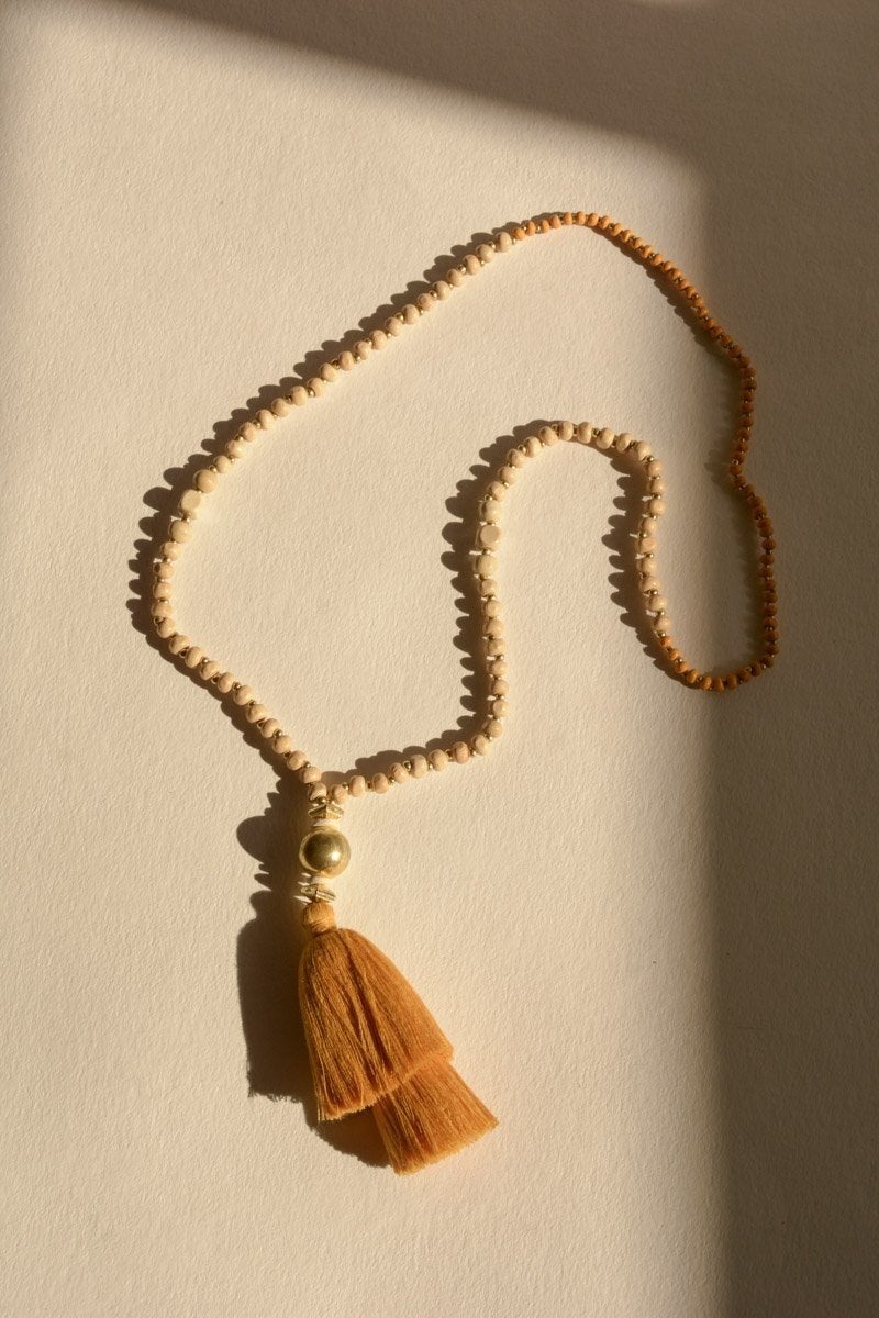 A long bohemian beaded necklace featuring colorful beads and stylish tassels, perfect for a chic look.