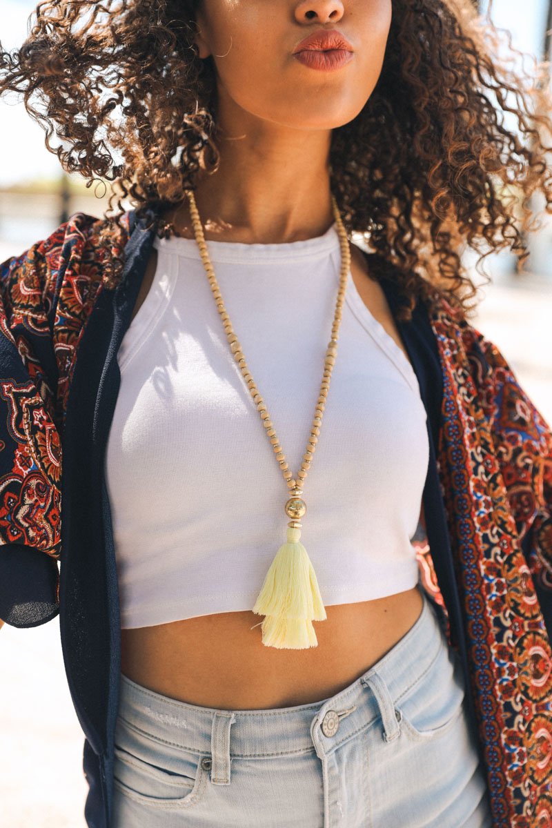 A long bohemian beaded necklace featuring colorful beads and stylish tassels, perfect for a chic look.