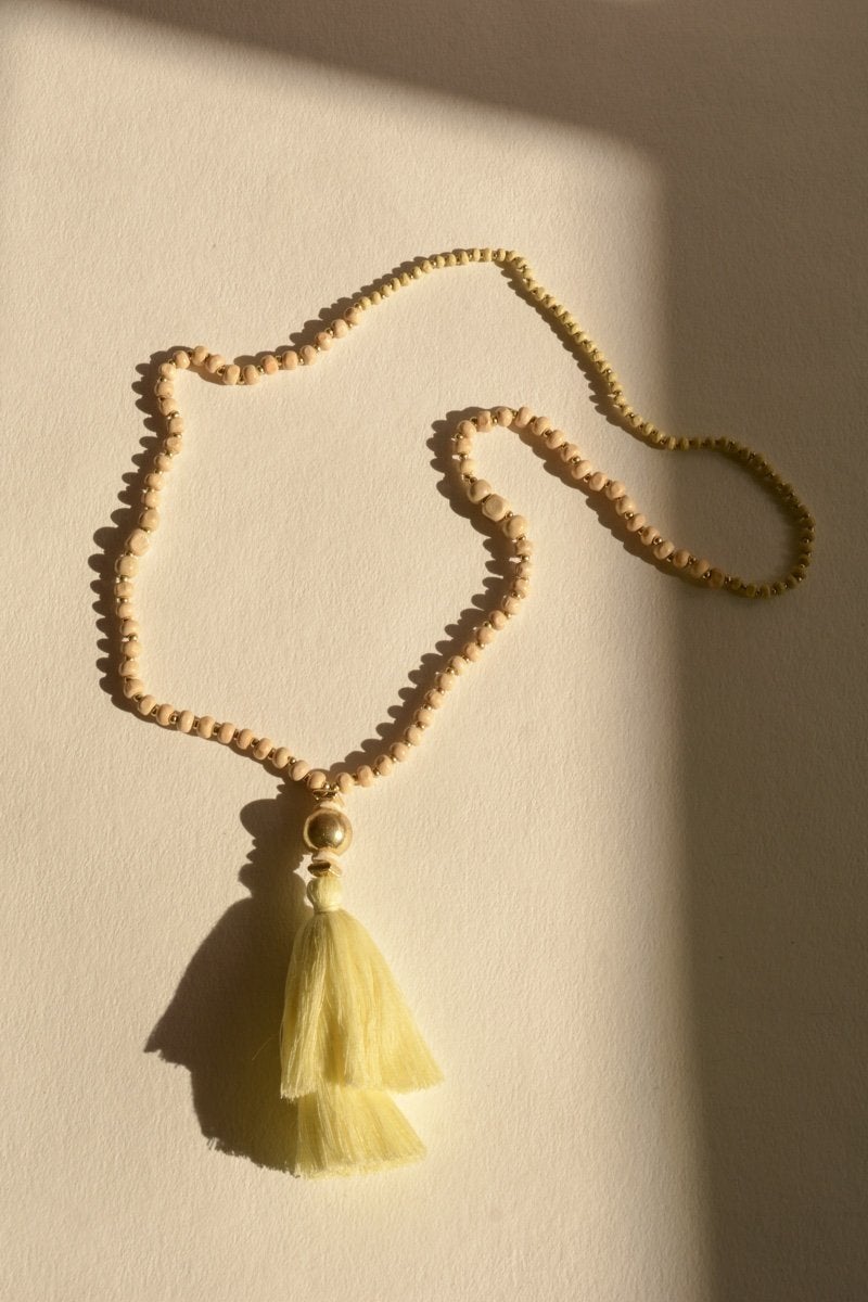 A long bohemian beaded necklace featuring colorful beads and stylish tassels, perfect for a chic look.