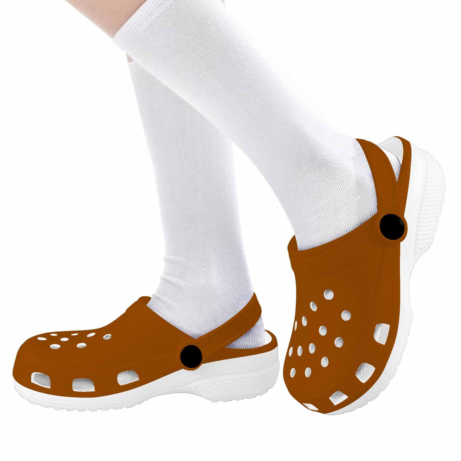 A pair of stylish brown clogs designed for youth, featuring a slip-on design, ventilation ports, and cushioned soles for comfort.