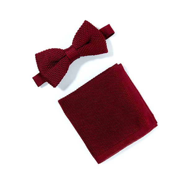 Burgundy knitted bow tie and matching pocket square set displayed elegantly on a white background.