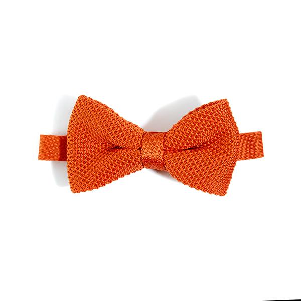 A vibrant burnt orange knitted bow tie displayed elegantly, showcasing its texture and adjustable strap.