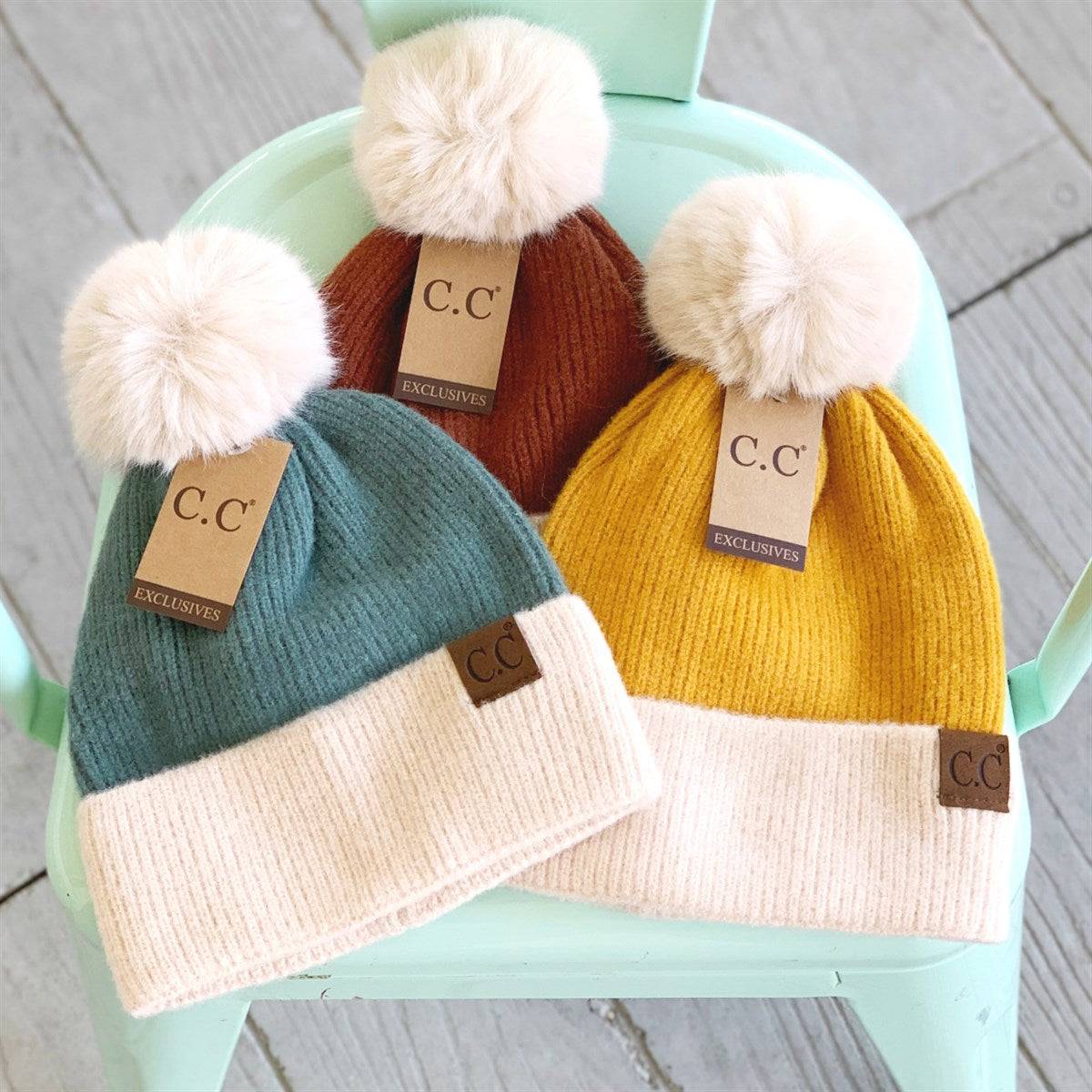 CC Festive Beanie featuring a faux fur pom and metallic detail, perfect for winter style.