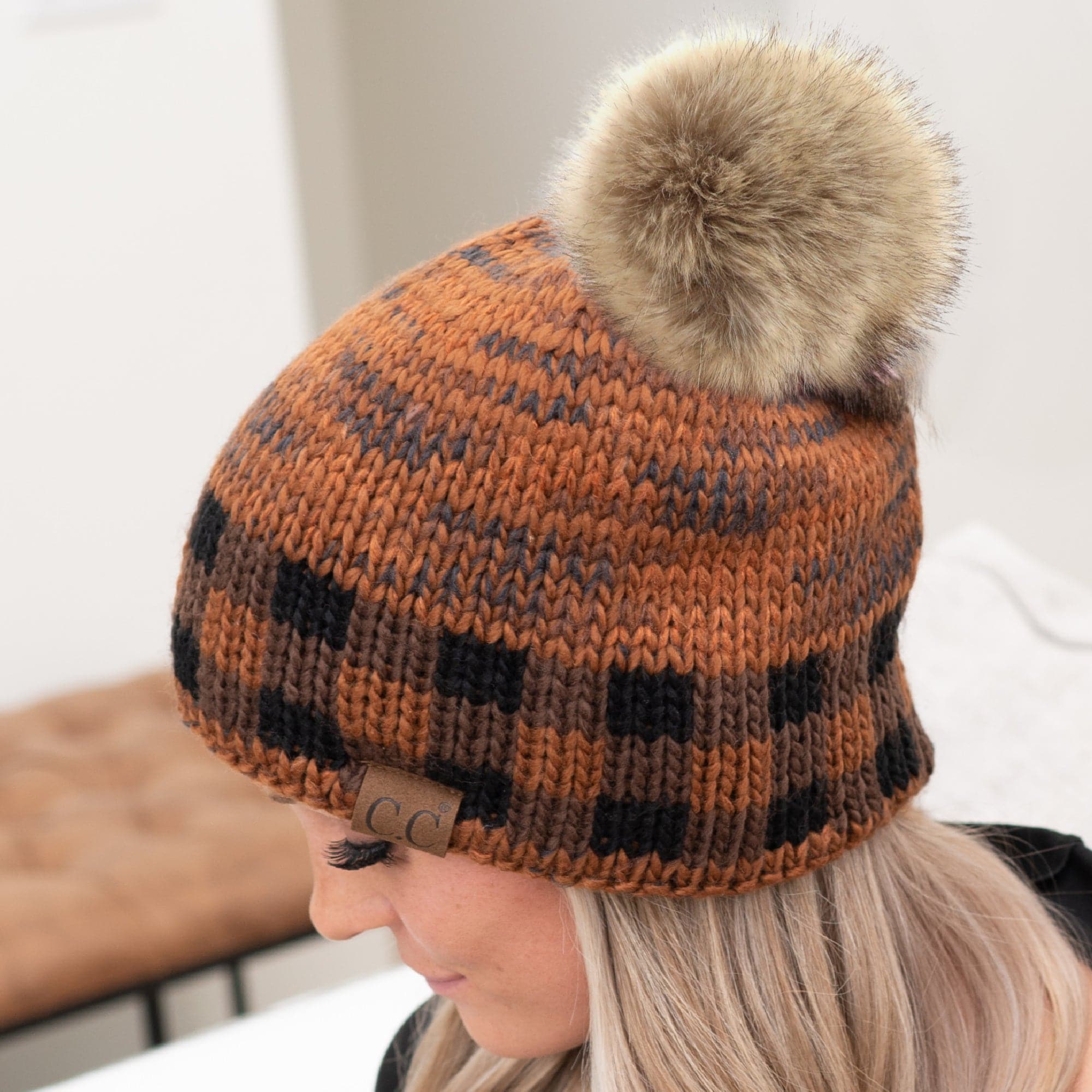 CC Fire Cozy Buffalo Plaid Beanie featuring a faux fur pom and stylish buffalo plaid design, perfect for winter wear.