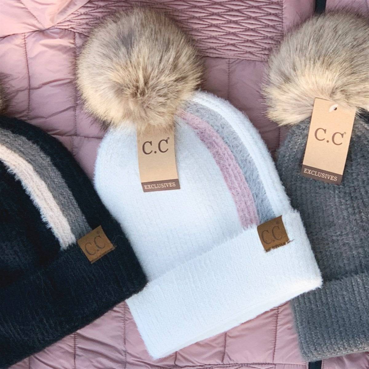 CC Sport Stripe Beanie featuring a soft faux fur pom-pom and stylish stripe design, perfect for winter wear.