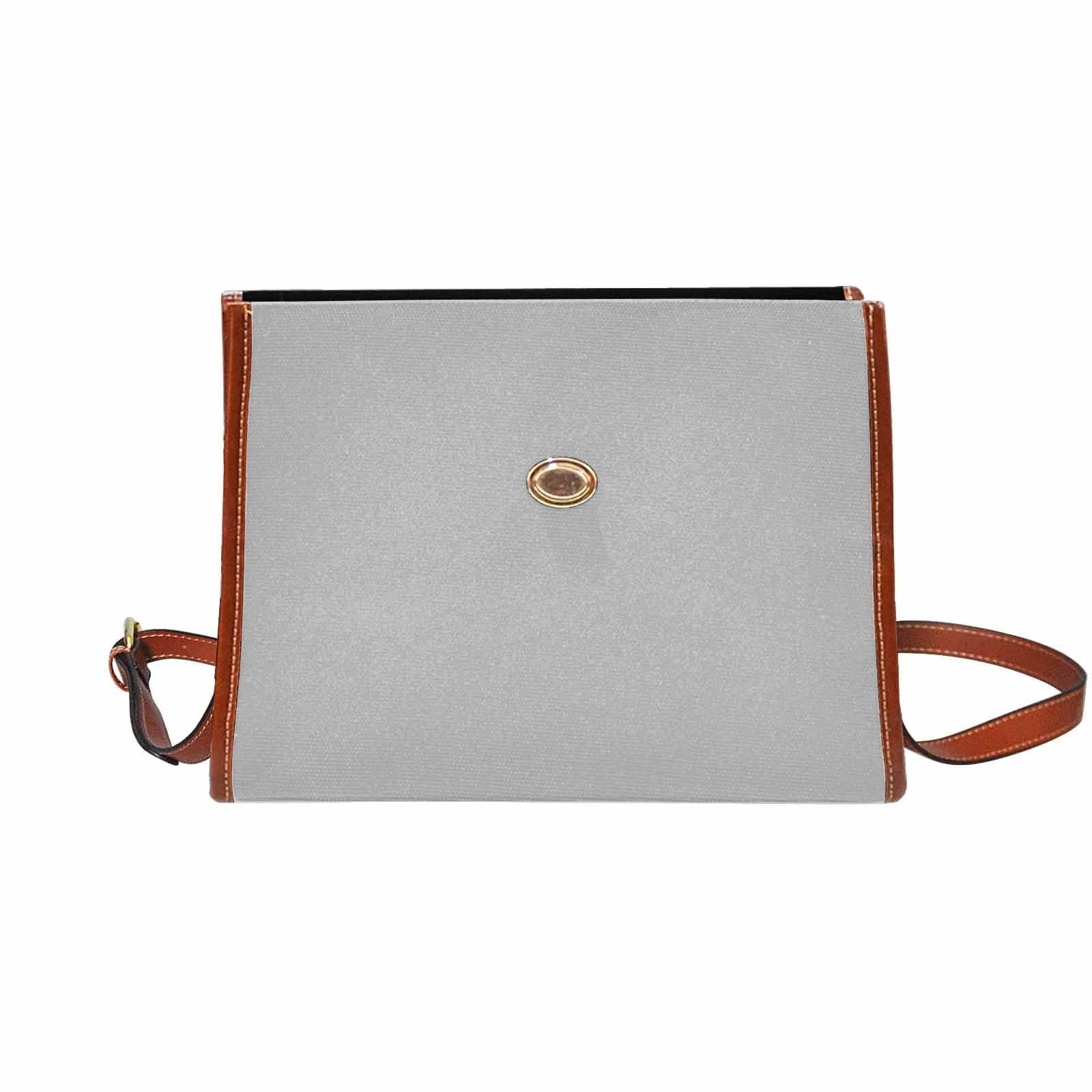 Light grey canvas bag with brown strap, featuring two interior pockets and a zipper pocket, ideal for versatile use.