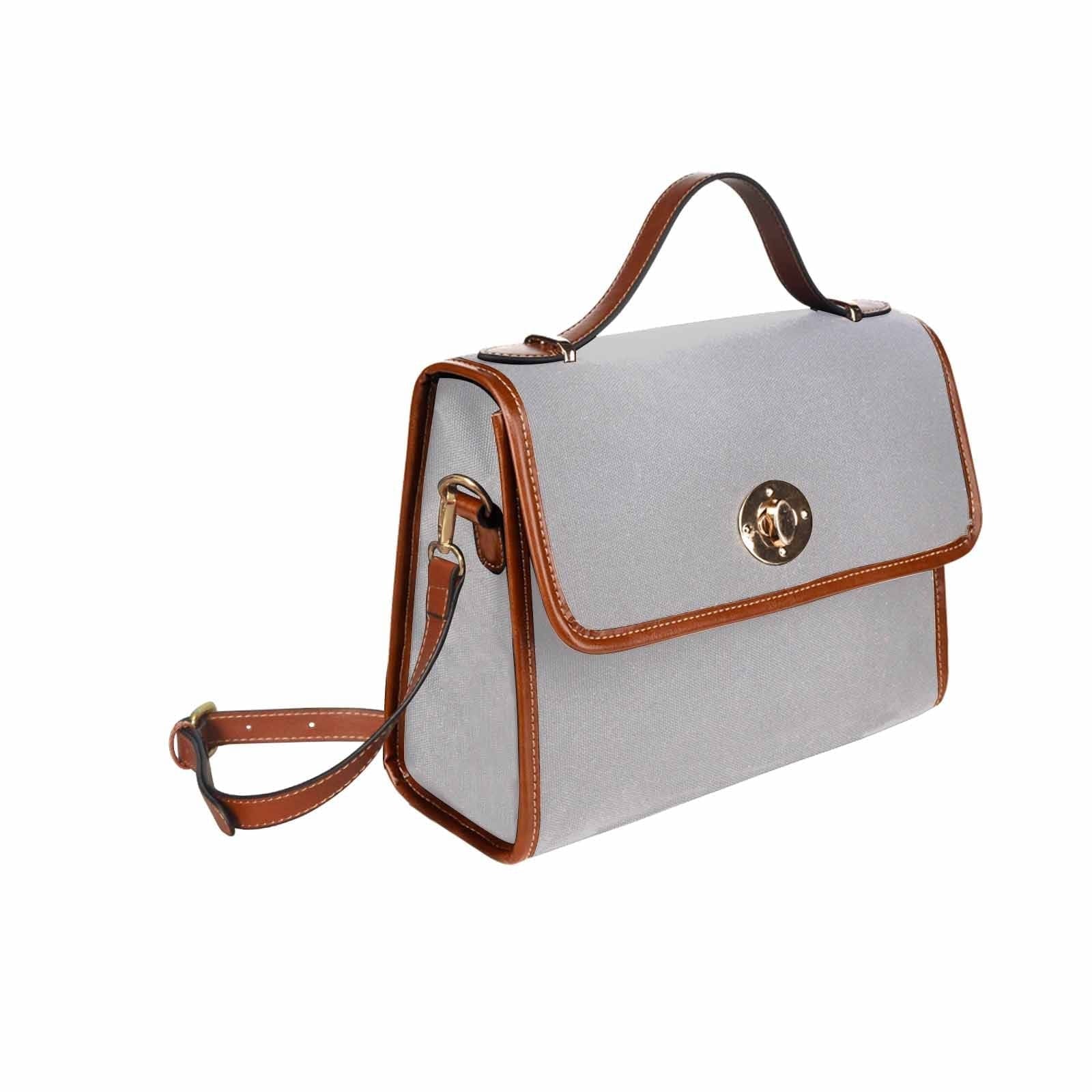 Light grey canvas bag with brown strap, featuring two interior pockets and a zipper pocket, ideal for versatile use.