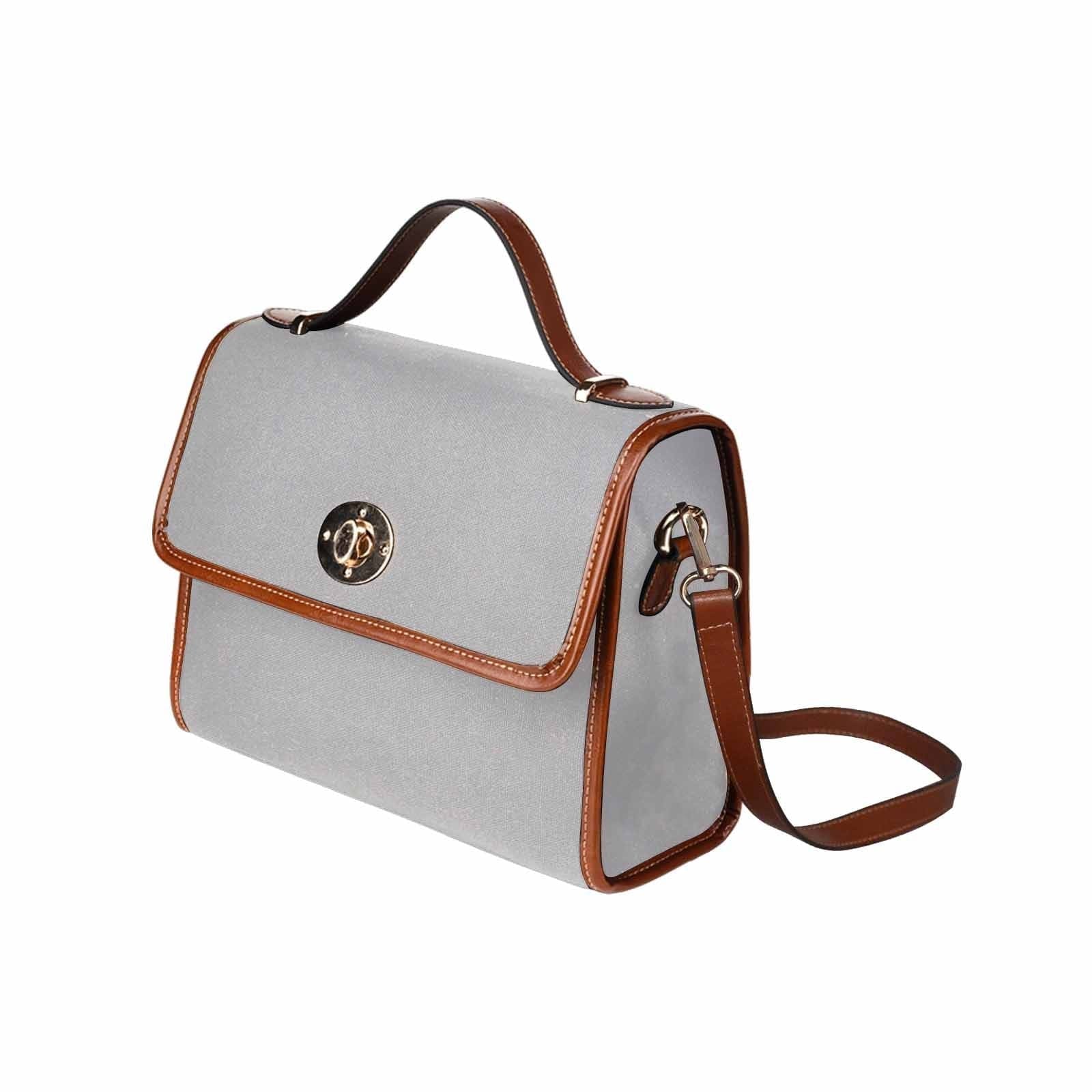 Light grey canvas bag with brown strap, featuring two interior pockets and a zipper pocket, ideal for versatile use.