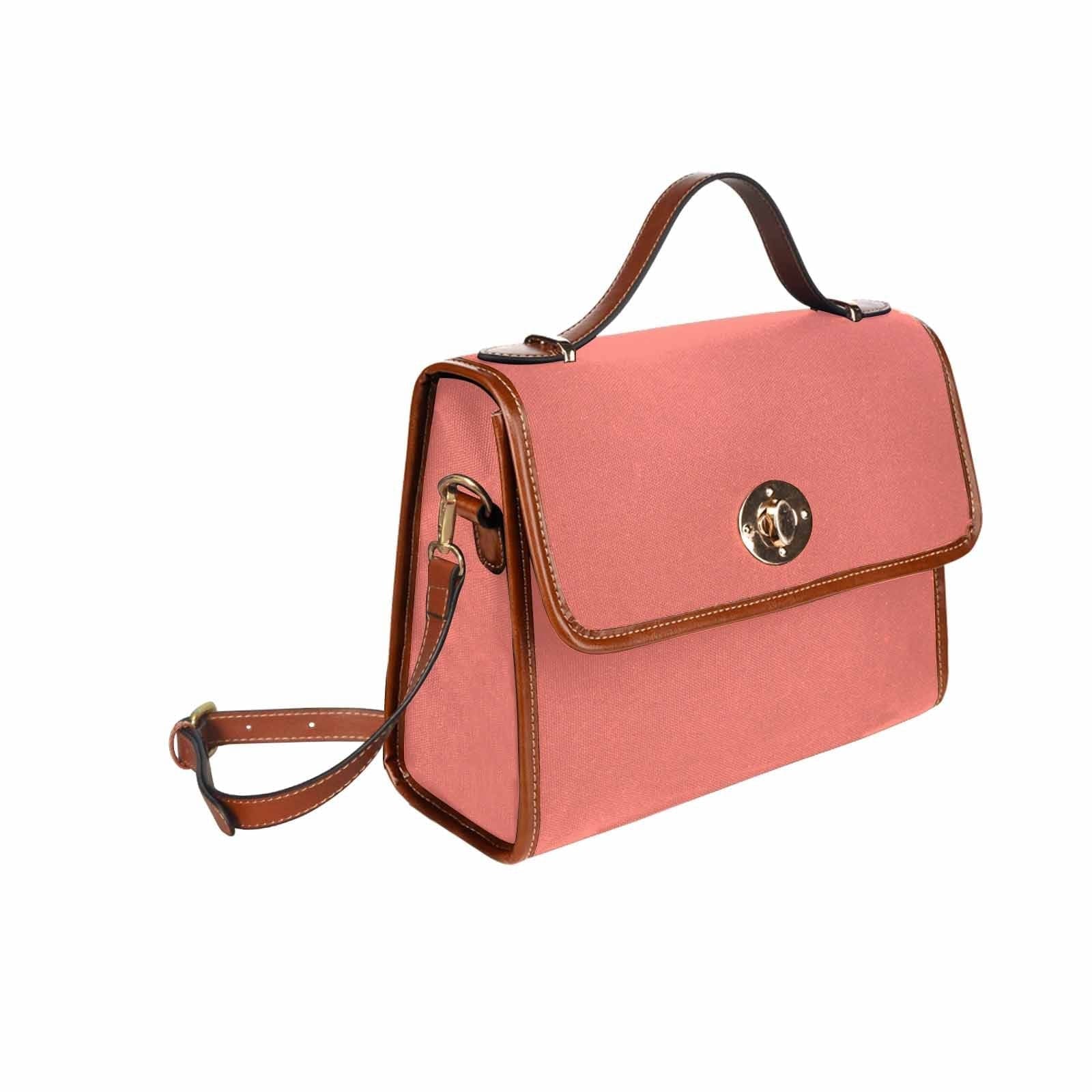 Salmon red canvas bag with brown strap, featuring two interior pockets and a zipper pocket, ideal for various uses.