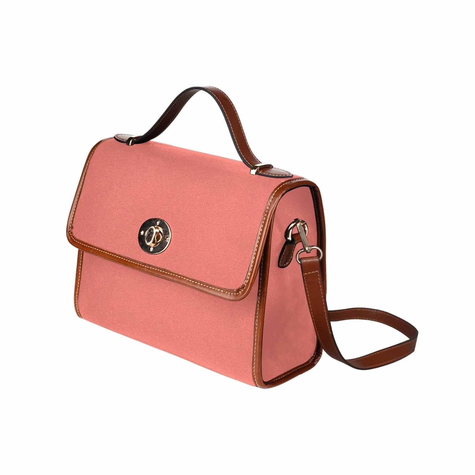 Salmon red canvas bag with brown strap, featuring two interior pockets and a zipper pocket, ideal for various uses.