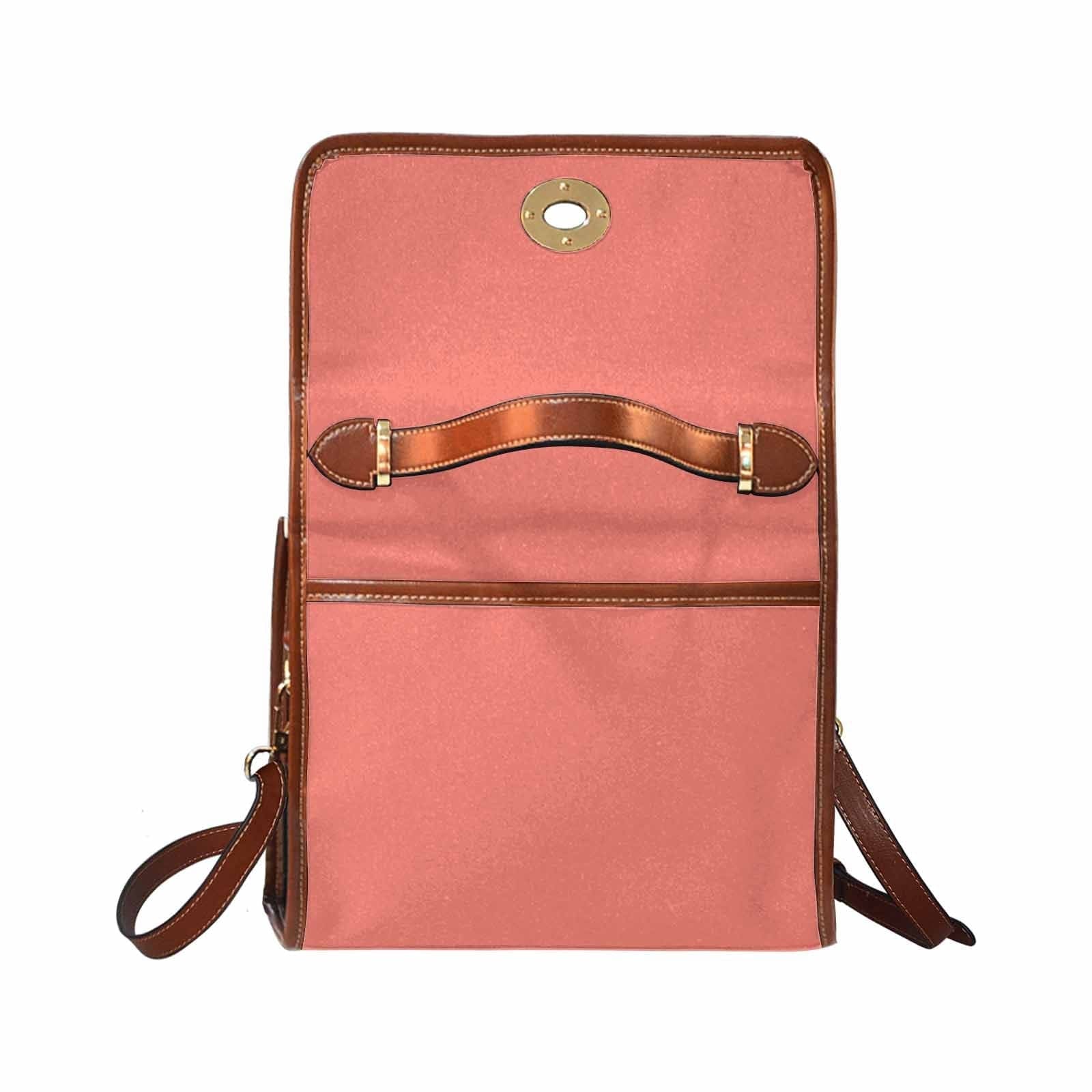 Salmon red canvas bag with brown strap, featuring two interior pockets and a zipper pocket, ideal for various uses.