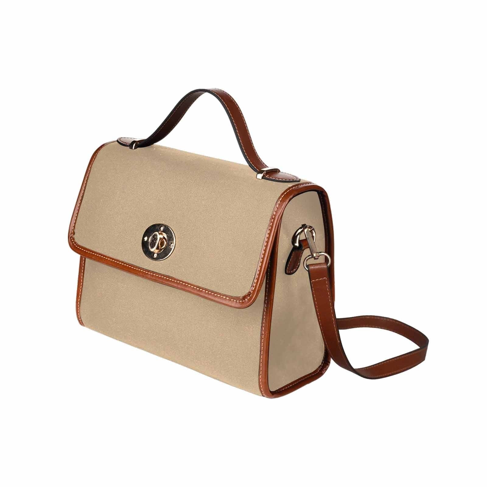 Tan brown canvas bag with brown strap, featuring two interior pockets and a zipper pocket.