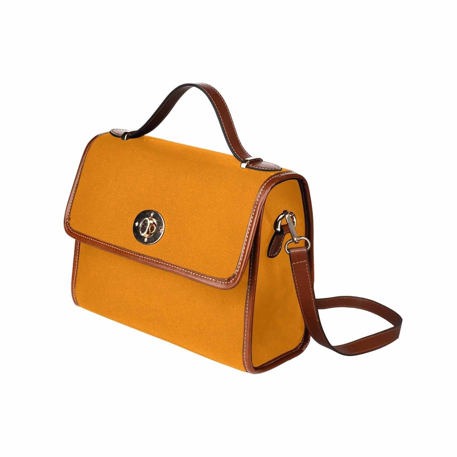 Stylish tangerine orange canvas bag with brown strap, featuring two interior pockets and a removable adjustable shoulder strap.