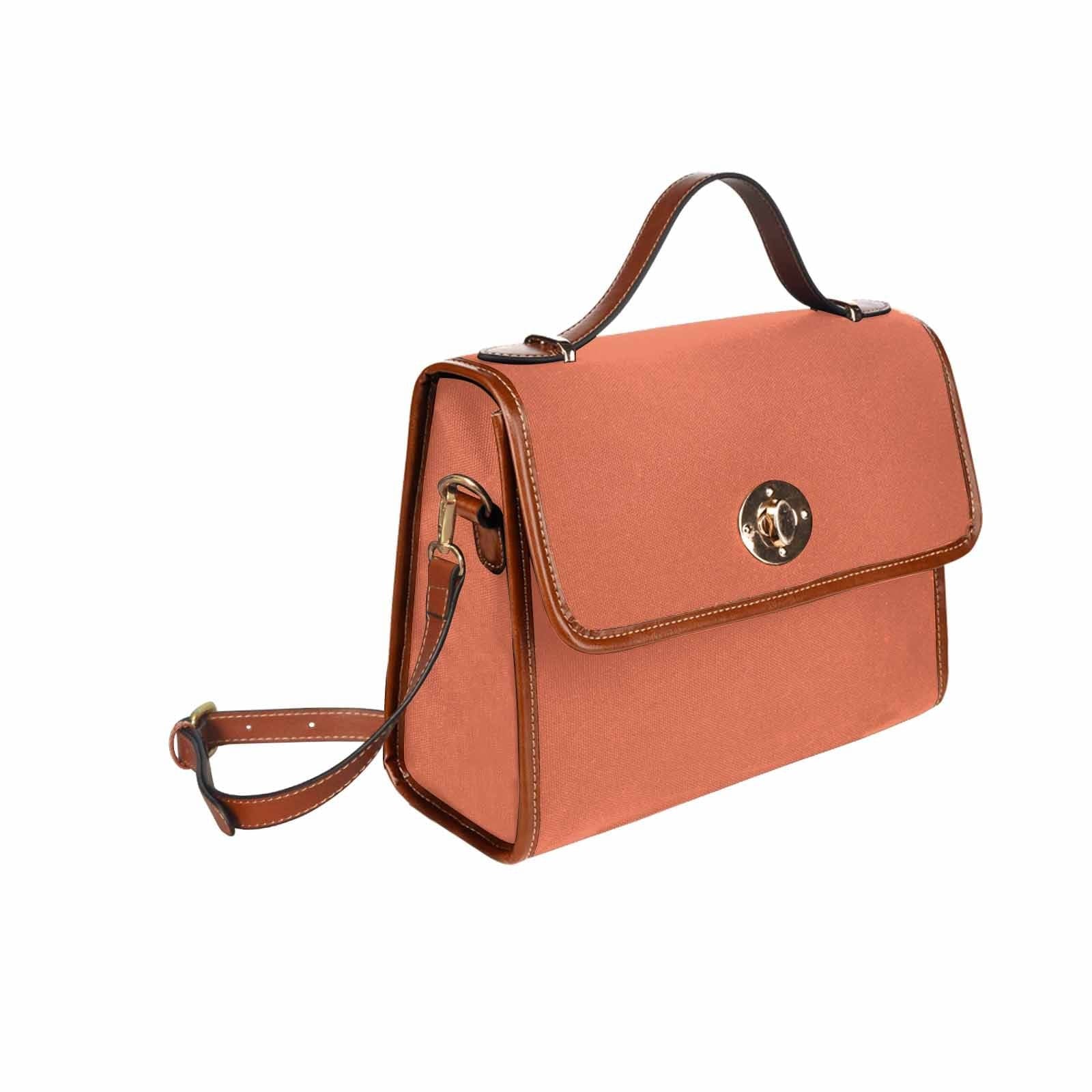 Stylish burnt sienna red canvas handbag with brown crossbody strap, featuring two interior pockets and a zipper pocket.