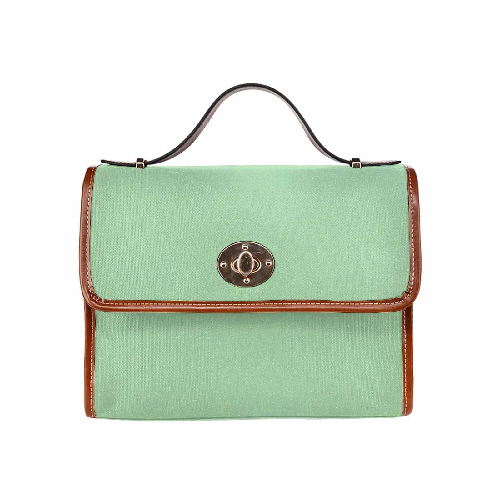 Celadon green canvas handbag with brown crossbody strap, featuring two interior pockets and a zipper pocket.