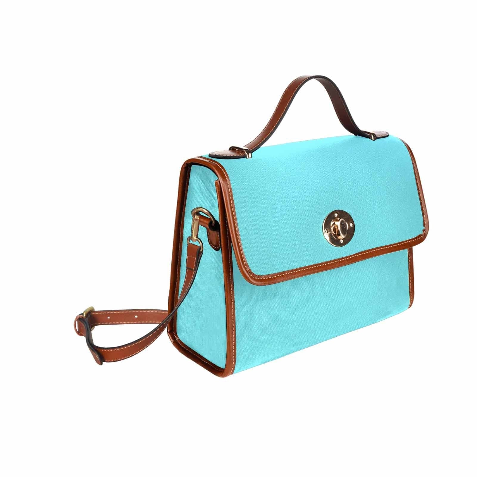 Electric blue canvas handbag with brown crossbody strap, featuring two interior pockets and a zipper pocket.