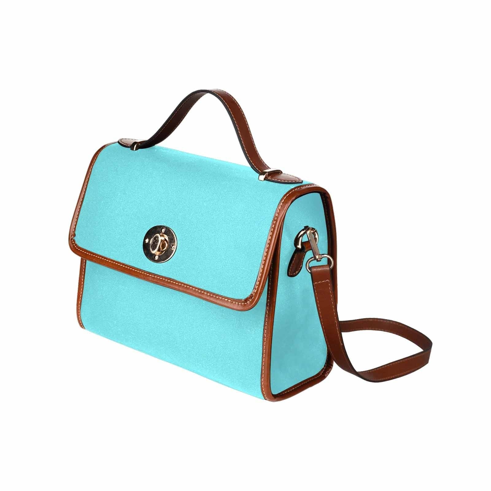 Electric blue canvas handbag with brown crossbody strap, featuring two interior pockets and a zipper pocket.