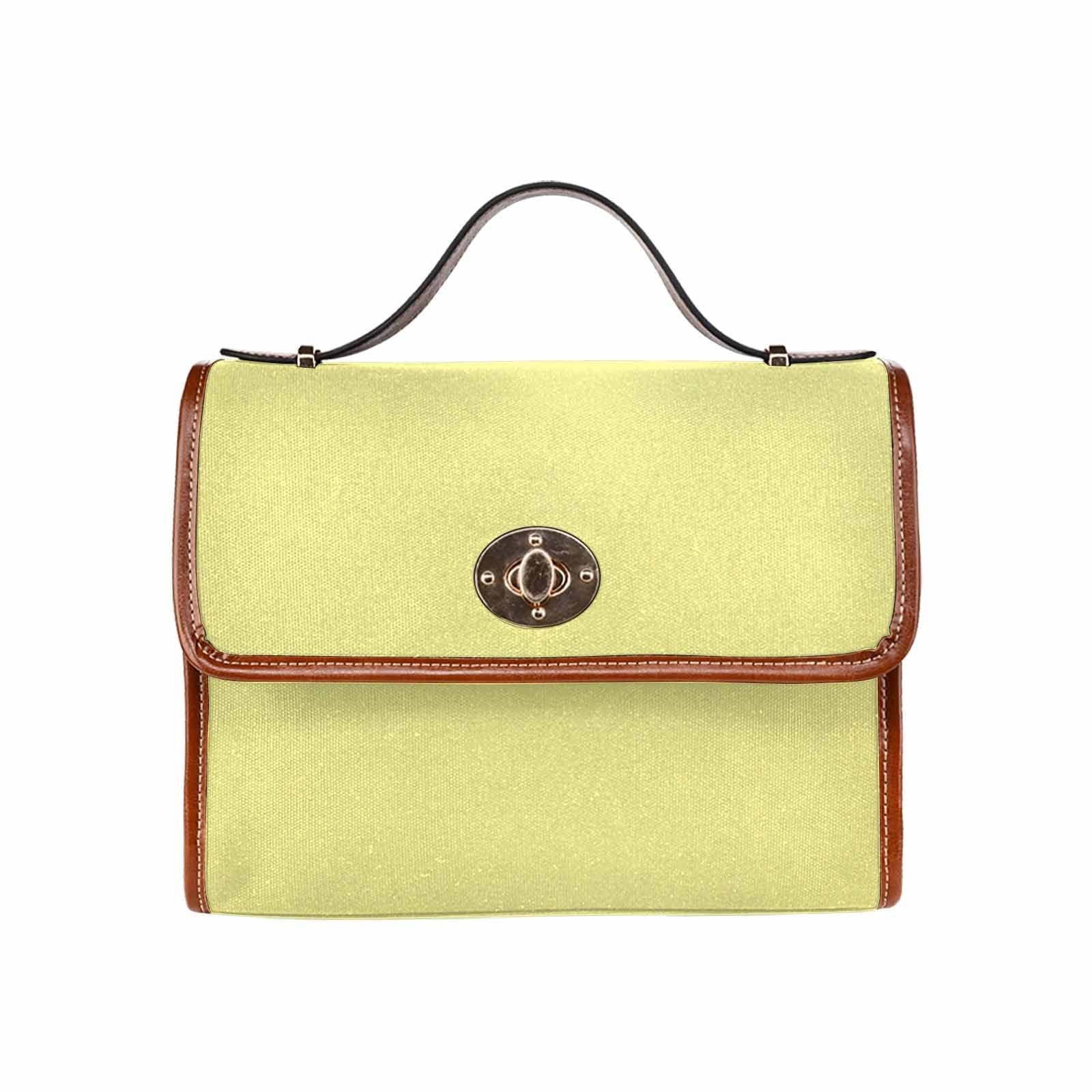 Pastel yellow canvas handbag with a brown crossbody strap, featuring two interior pockets and a zipper pocket.