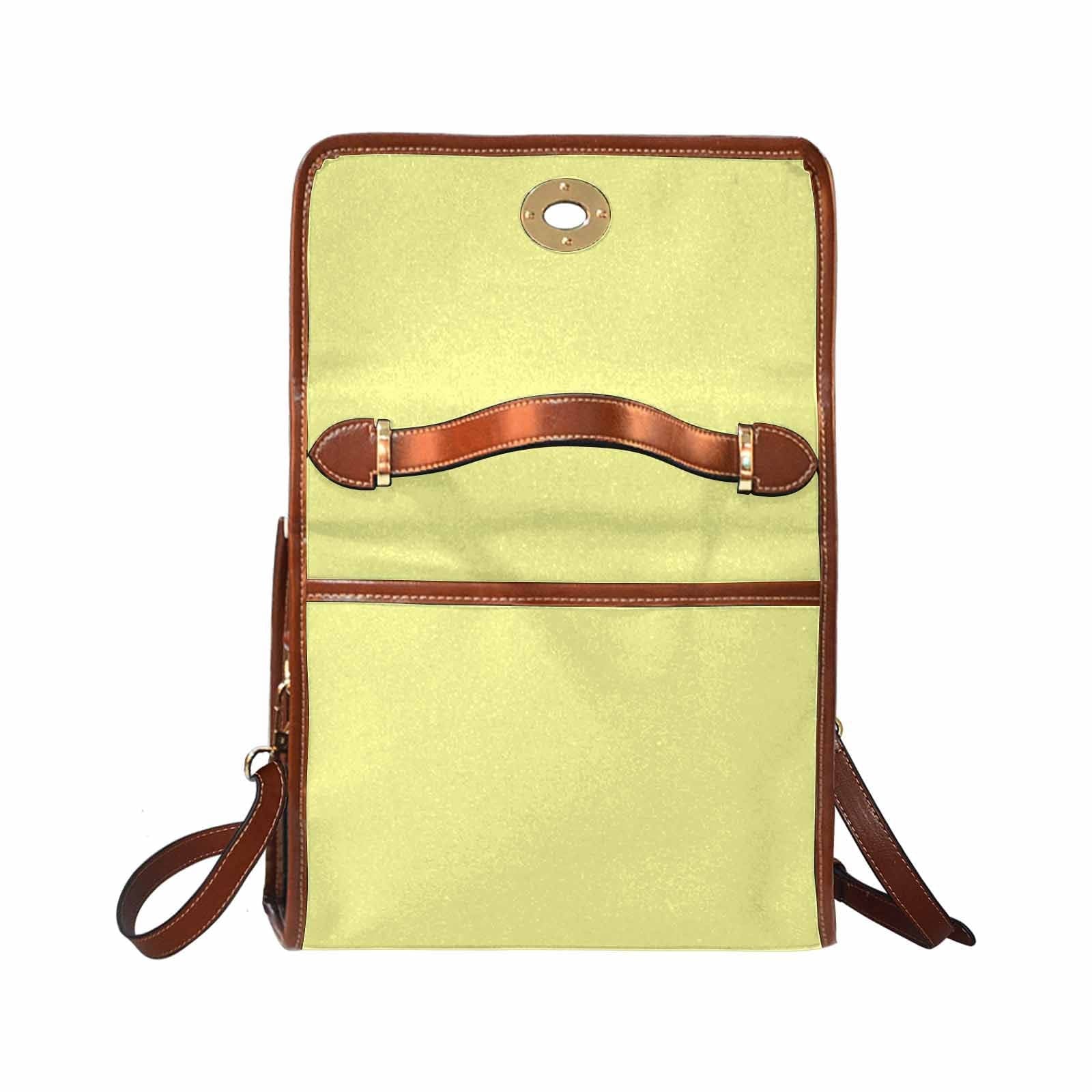 Pastel yellow canvas handbag with a brown crossbody strap, featuring two interior pockets and a zipper pocket.