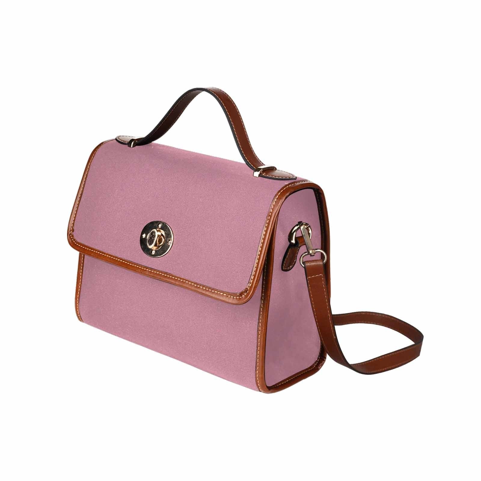 Puce red waterproof canvas handbag with brown crossbody strap, featuring two interior pockets and a zipper pocket.