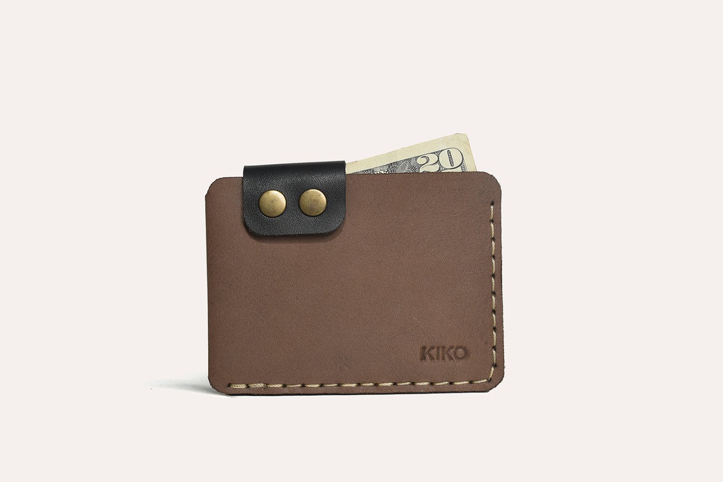 A stylish Card Wallet made of smooth leather, featuring a button flap closure and artisan stitching, perfect for holding cards and cash.