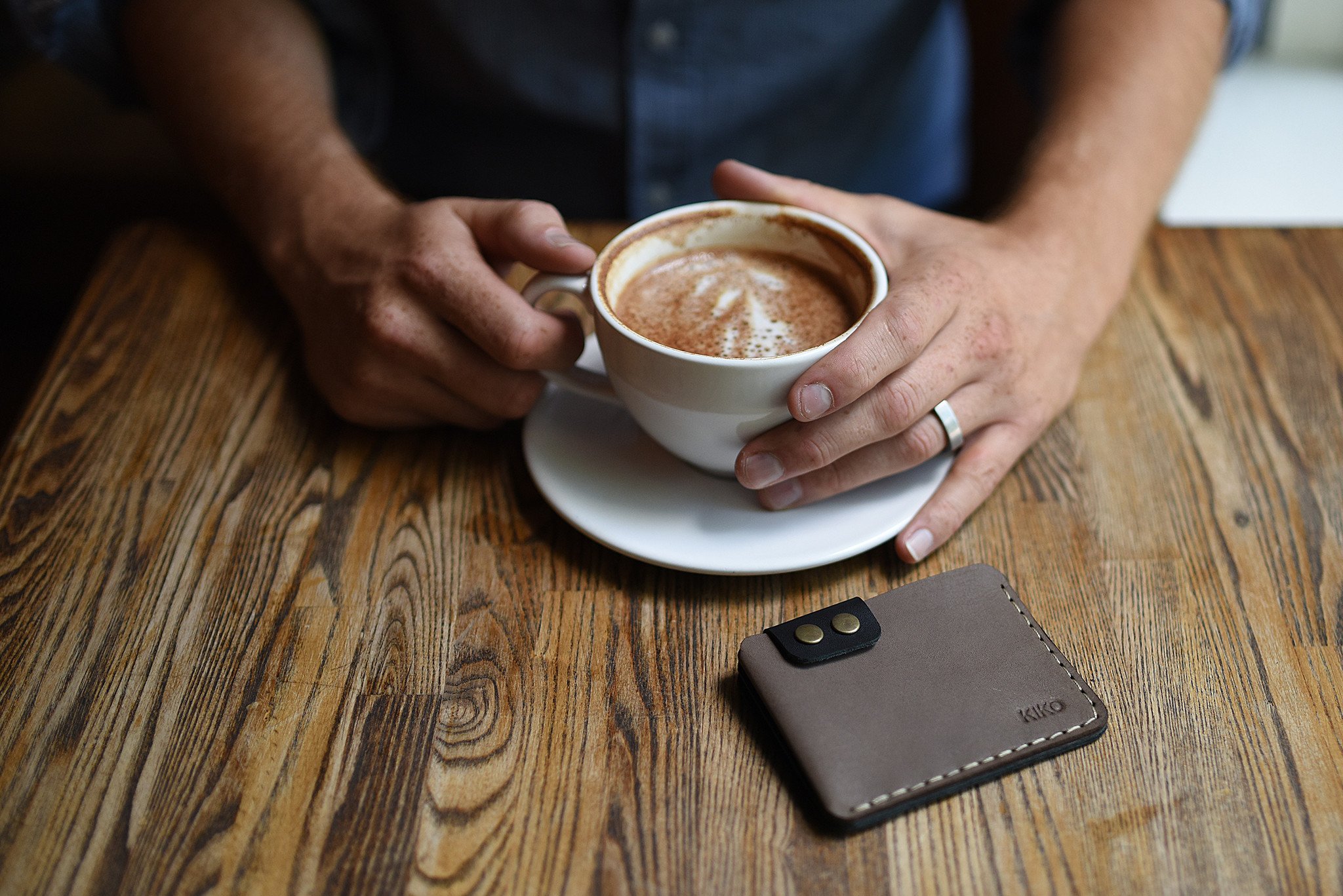 A stylish Card Wallet made of smooth leather, featuring a button flap closure and artisan stitching, perfect for holding cards and cash.