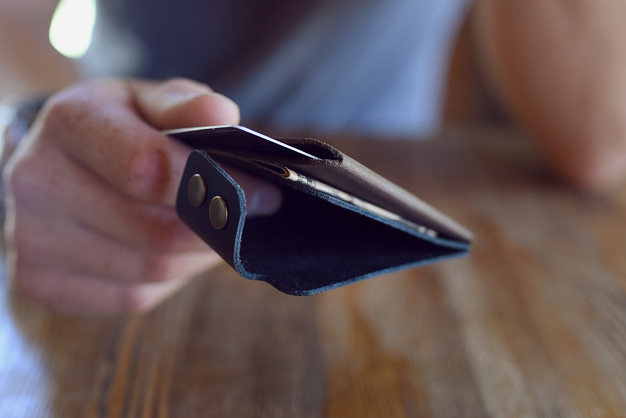 A stylish Card Wallet made of smooth leather, featuring a button flap closure and artisan stitching, perfect for holding cards and cash.