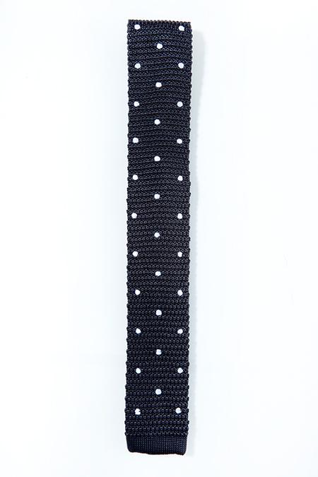 Charcoal knitted tie with white polka dots, showcasing a luxurious silk texture and square end design.