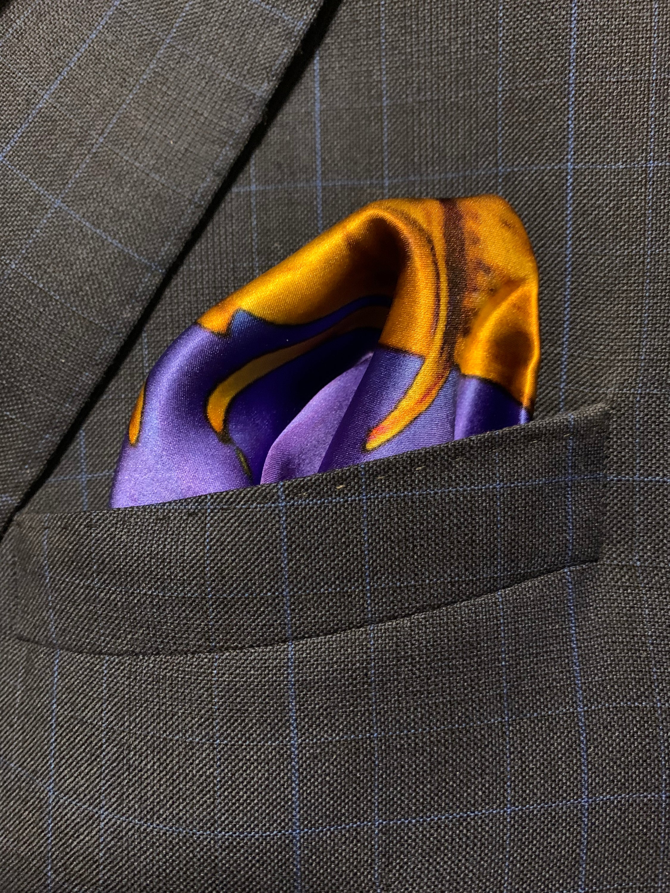 A vibrant blue and yellow pocket square featuring a bold design, symbolizing optimism and strength, perfect for stylish gentlemen.