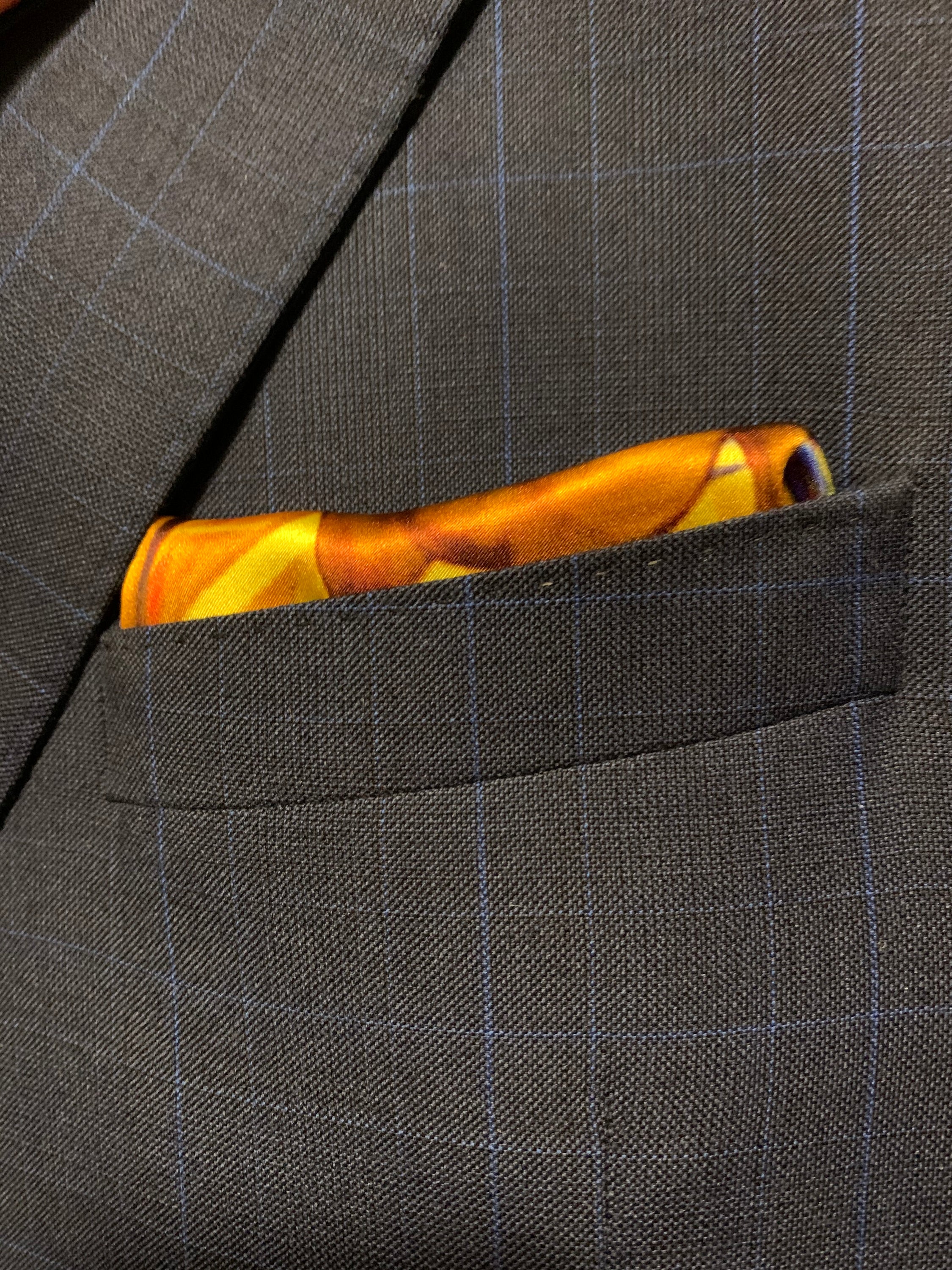 A vibrant blue and yellow pocket square featuring a bold design, symbolizing optimism and strength, perfect for stylish gentlemen.