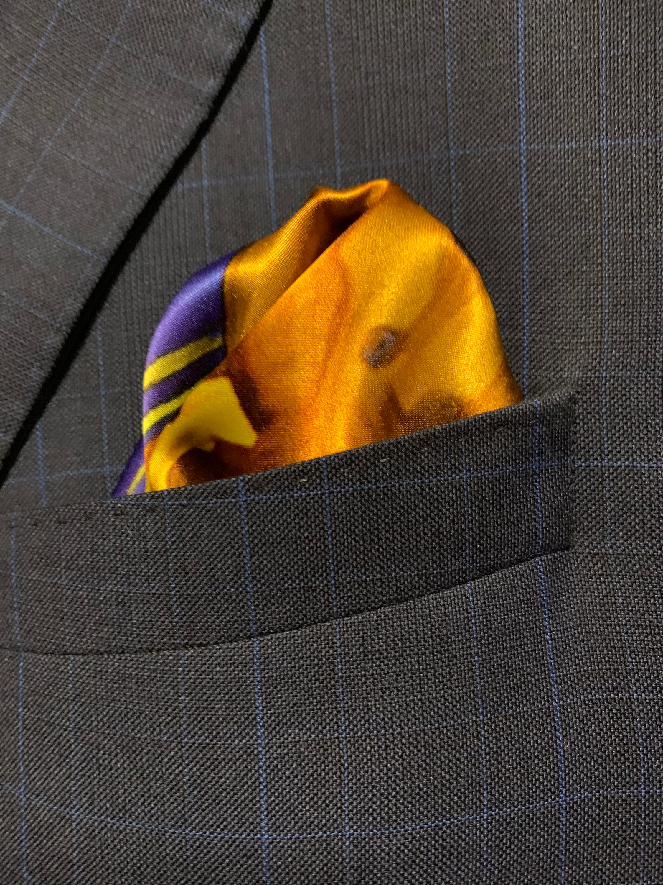 A vibrant blue and yellow pocket square featuring a bold design, symbolizing optimism and strength, perfect for stylish gentlemen.