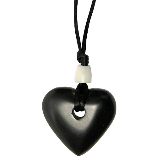 Handcrafted Coal Heart Pendant with tagua nut bead on a black cord, symbolizing ethical craftsmanship.