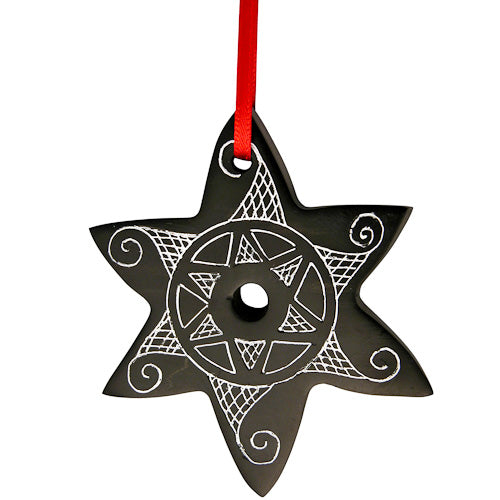 A beautifully hand-carved coal star ornament, polished to shine, suspended with a red ribbon, symbolizing artisan craftsmanship from Colombia.