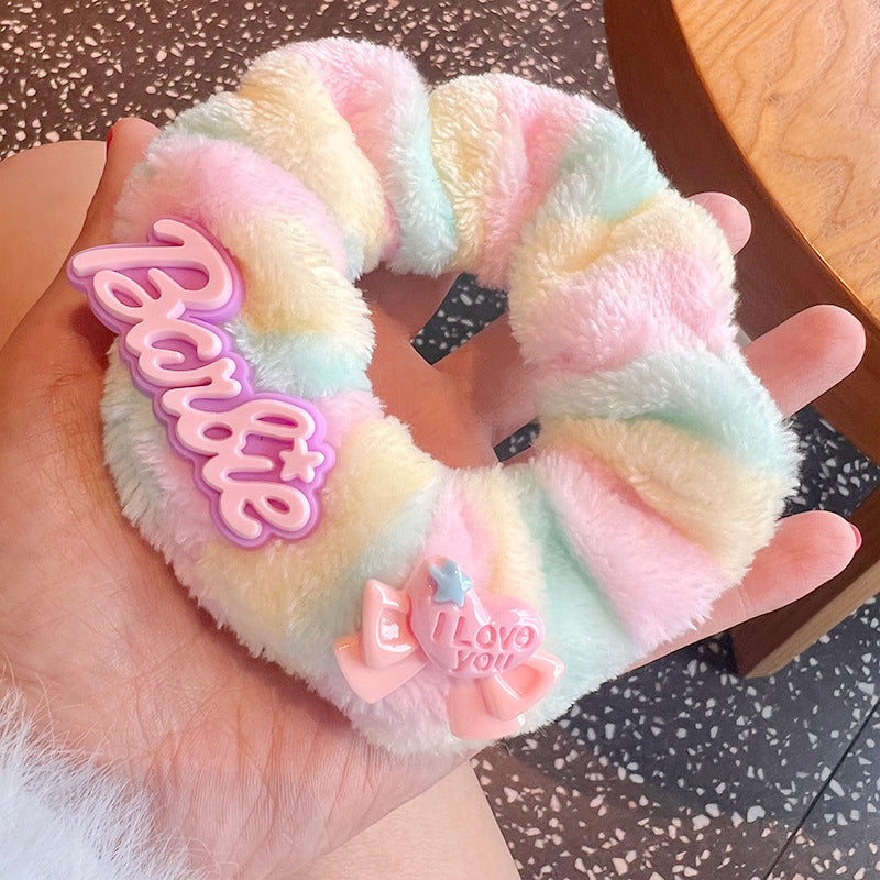 A vibrant set of four plush Barbie hair scrunchies in various playful designs, perfect for adding color to hairstyles.